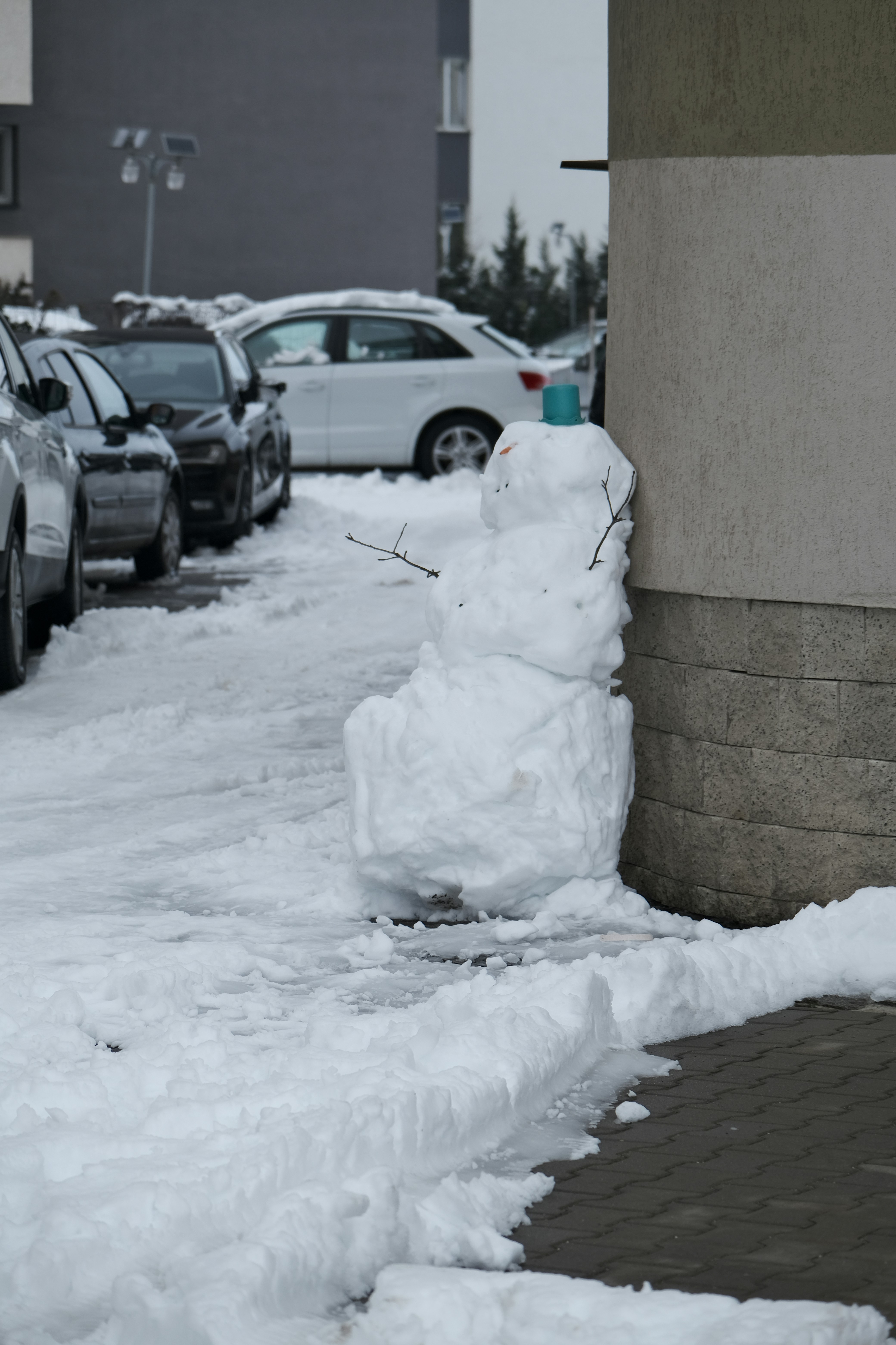 Bonhomme de neige construit à côté d’un bâtiment dans la neige