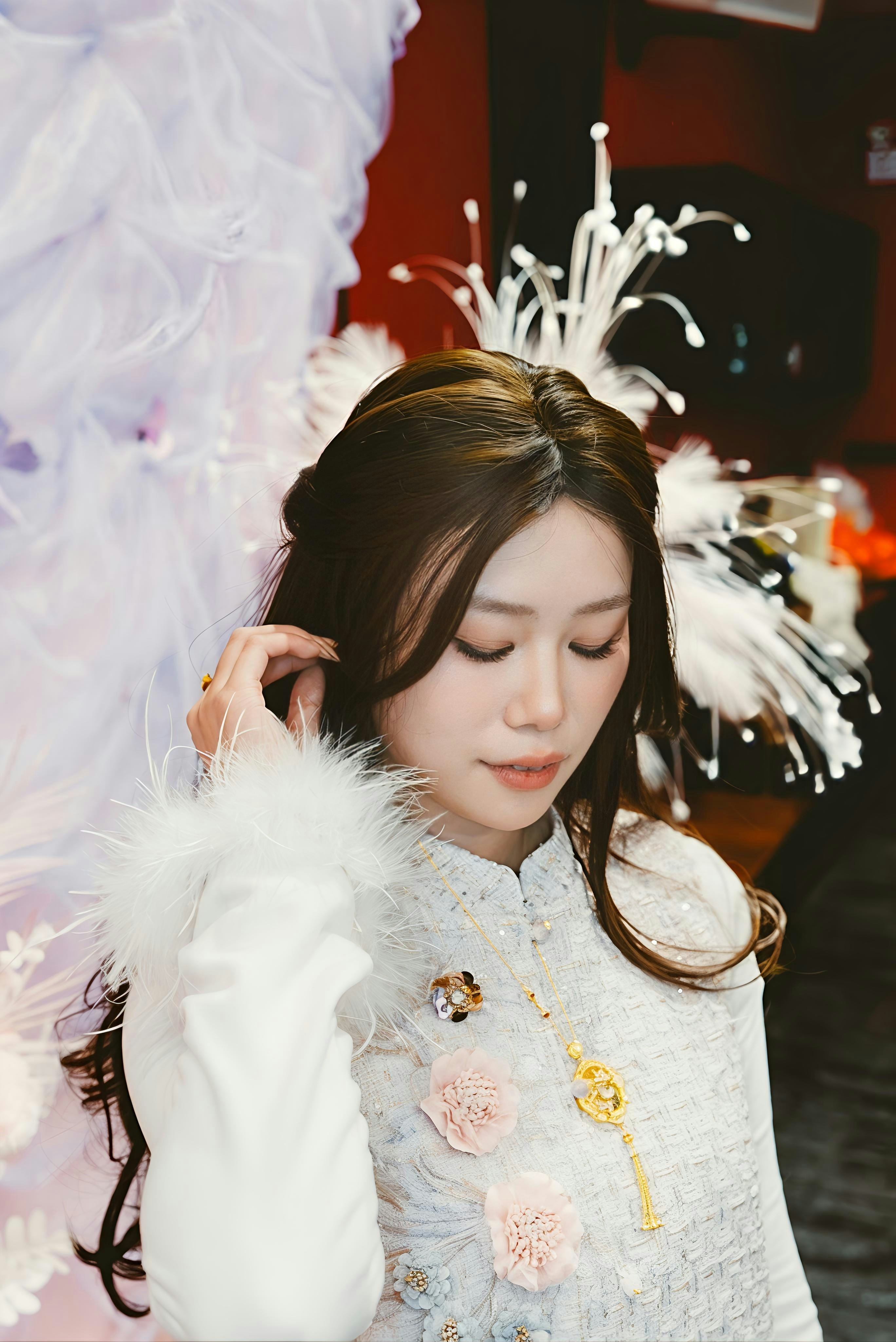 A woman in a white ornate dress with feathered sleeves