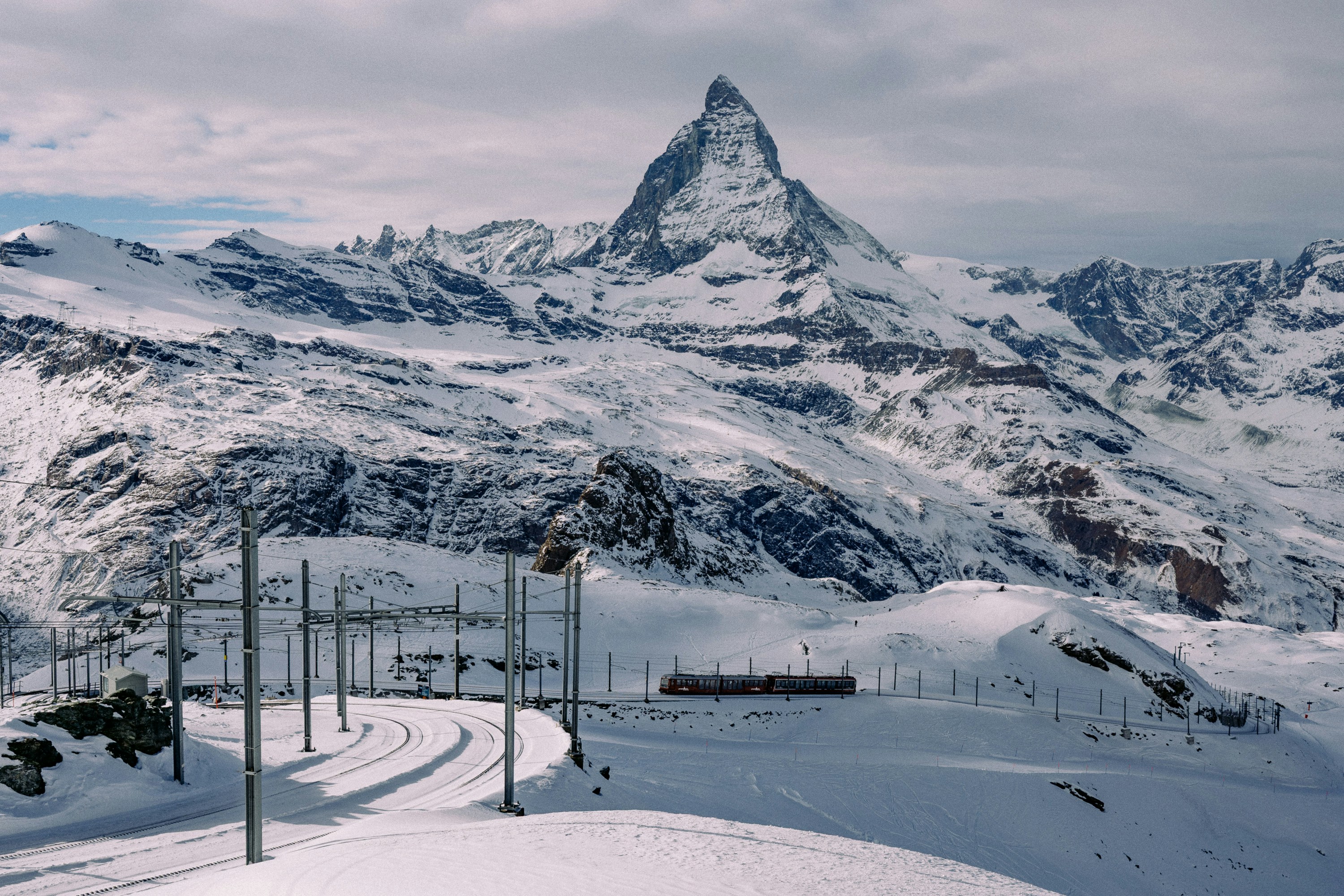 Snowy mountain landscape with train tracks and matterhorn.