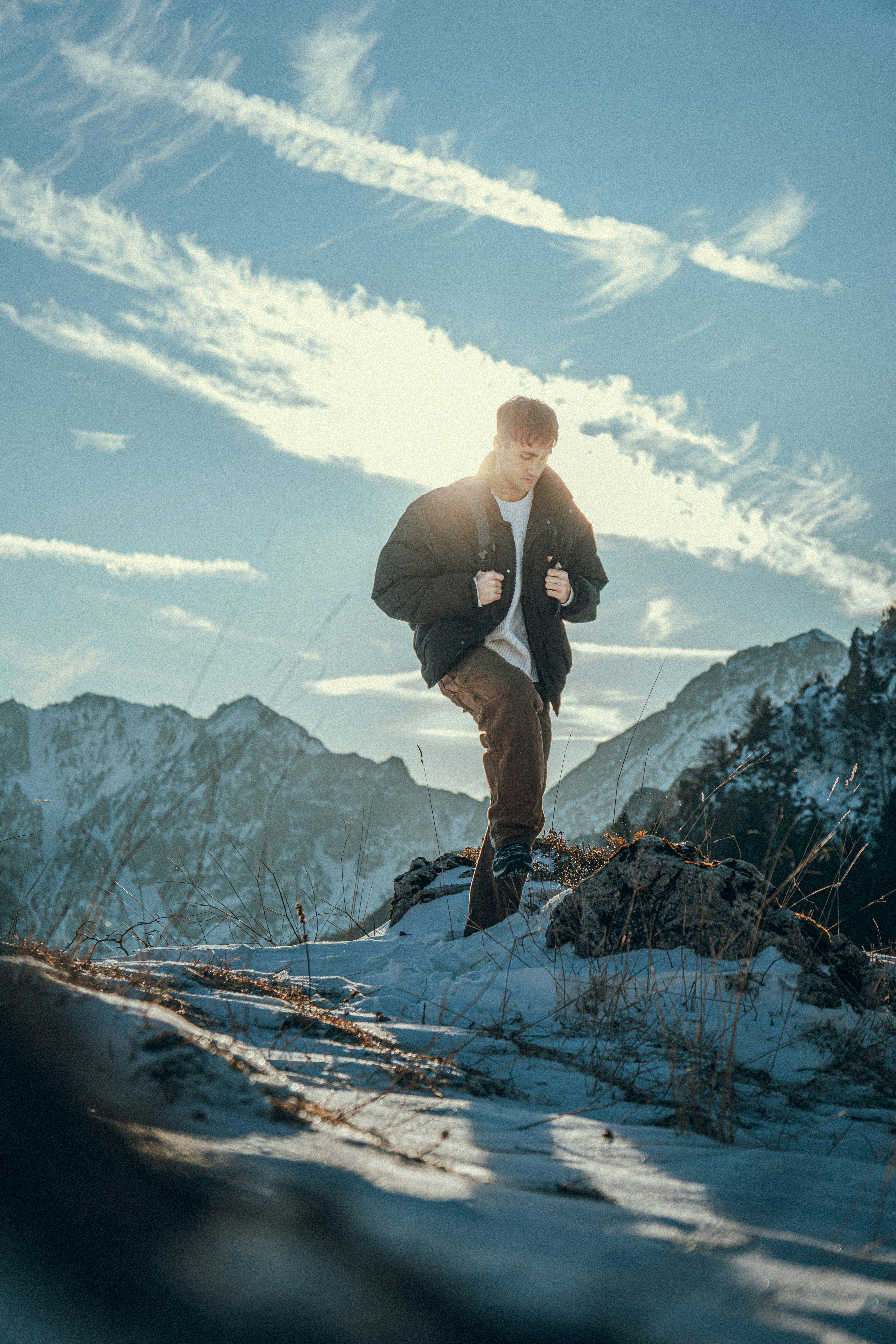 Man hiking on a snowy mountain under a bright sky