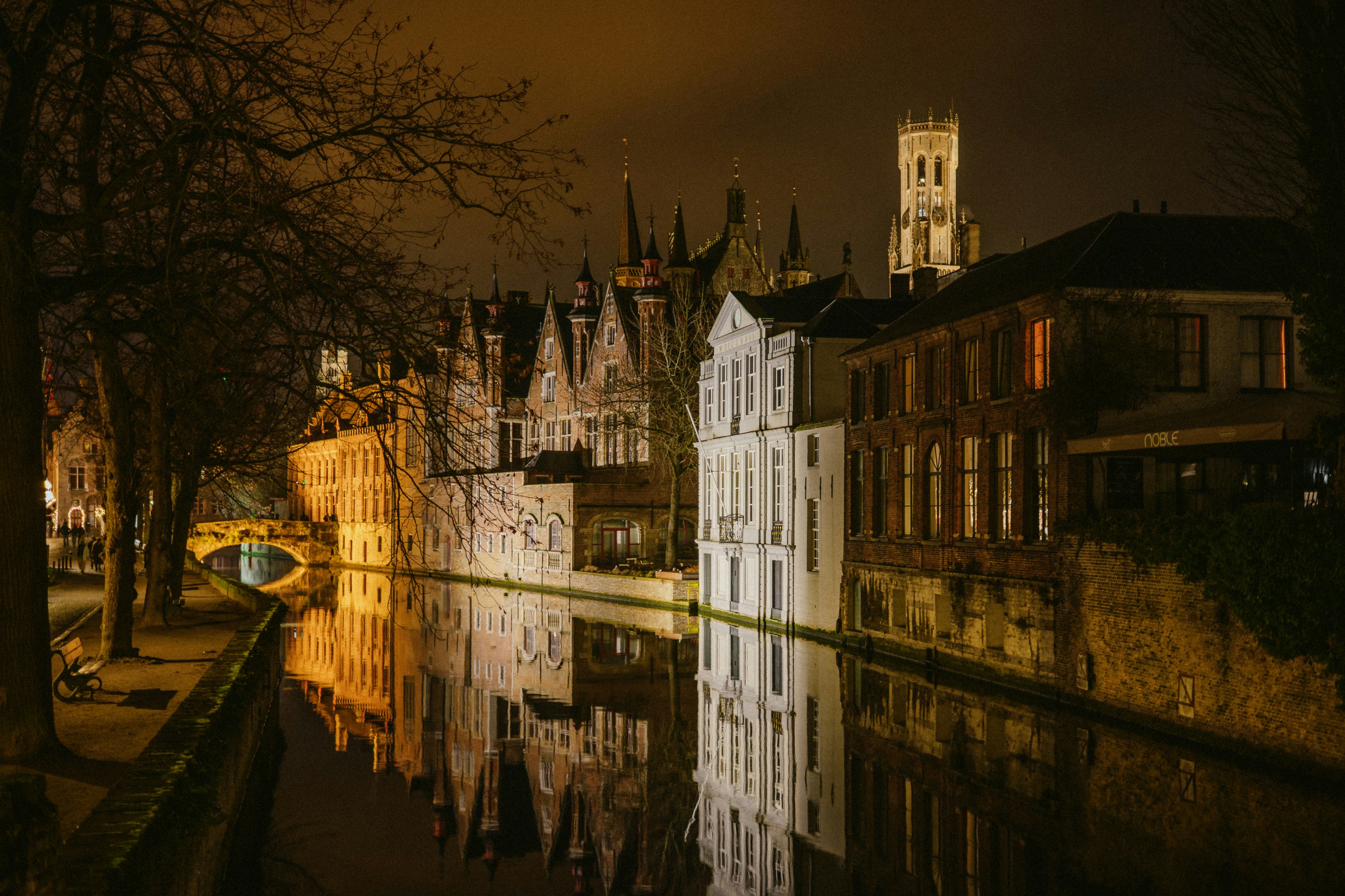 Historic buildings reflected in a canal at night.