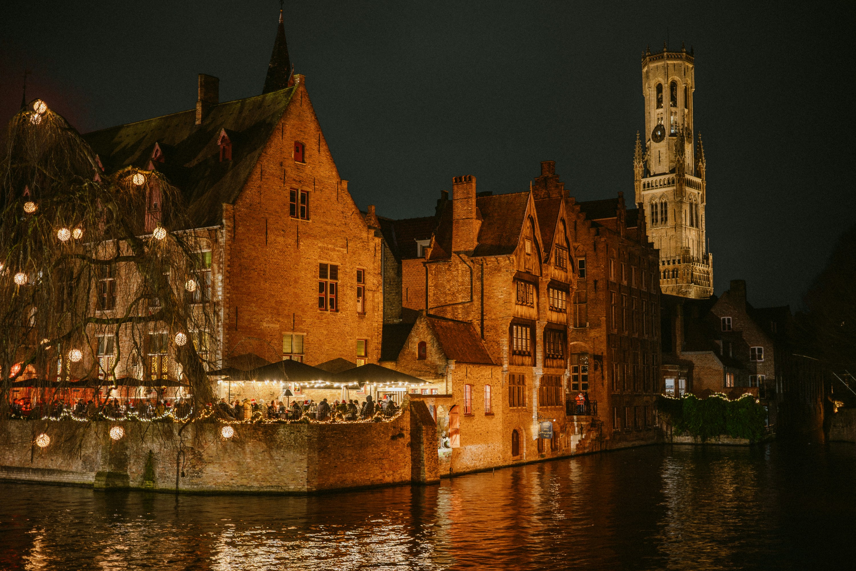 Historic buildings illuminated at night along a canal.
