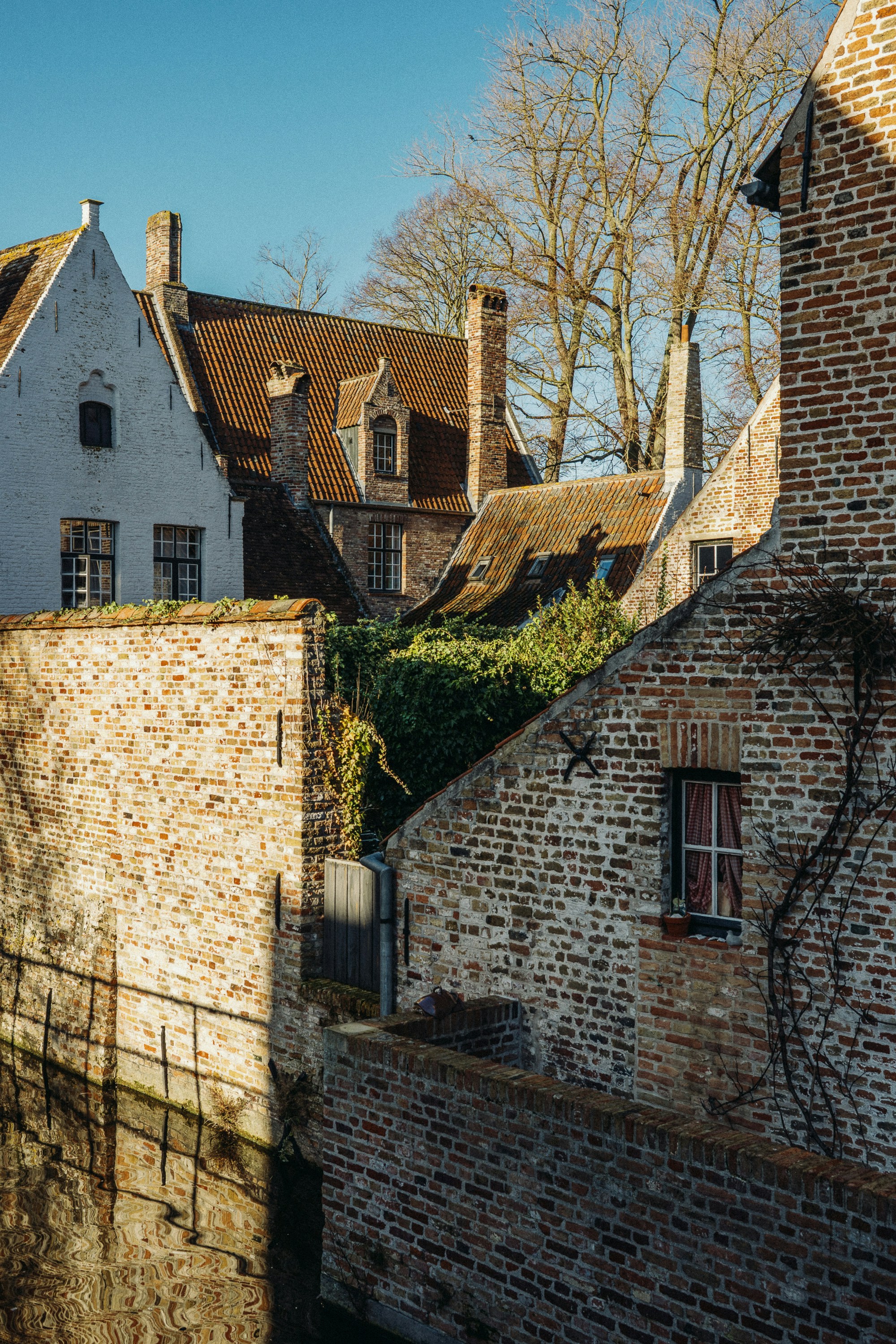 Old brick buildings beside a canal in bruges.