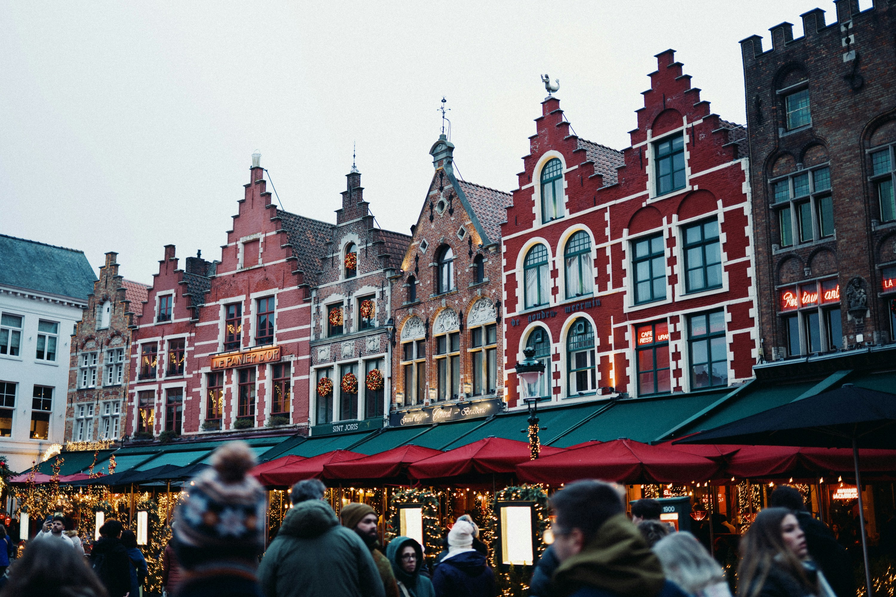 Colorful historic buildings line a bustling market square.