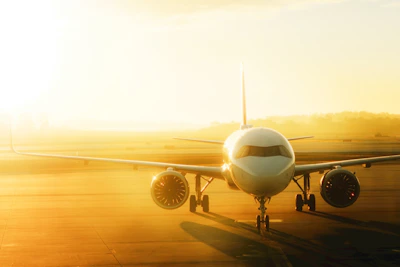Airplane on tarmac at sunrise