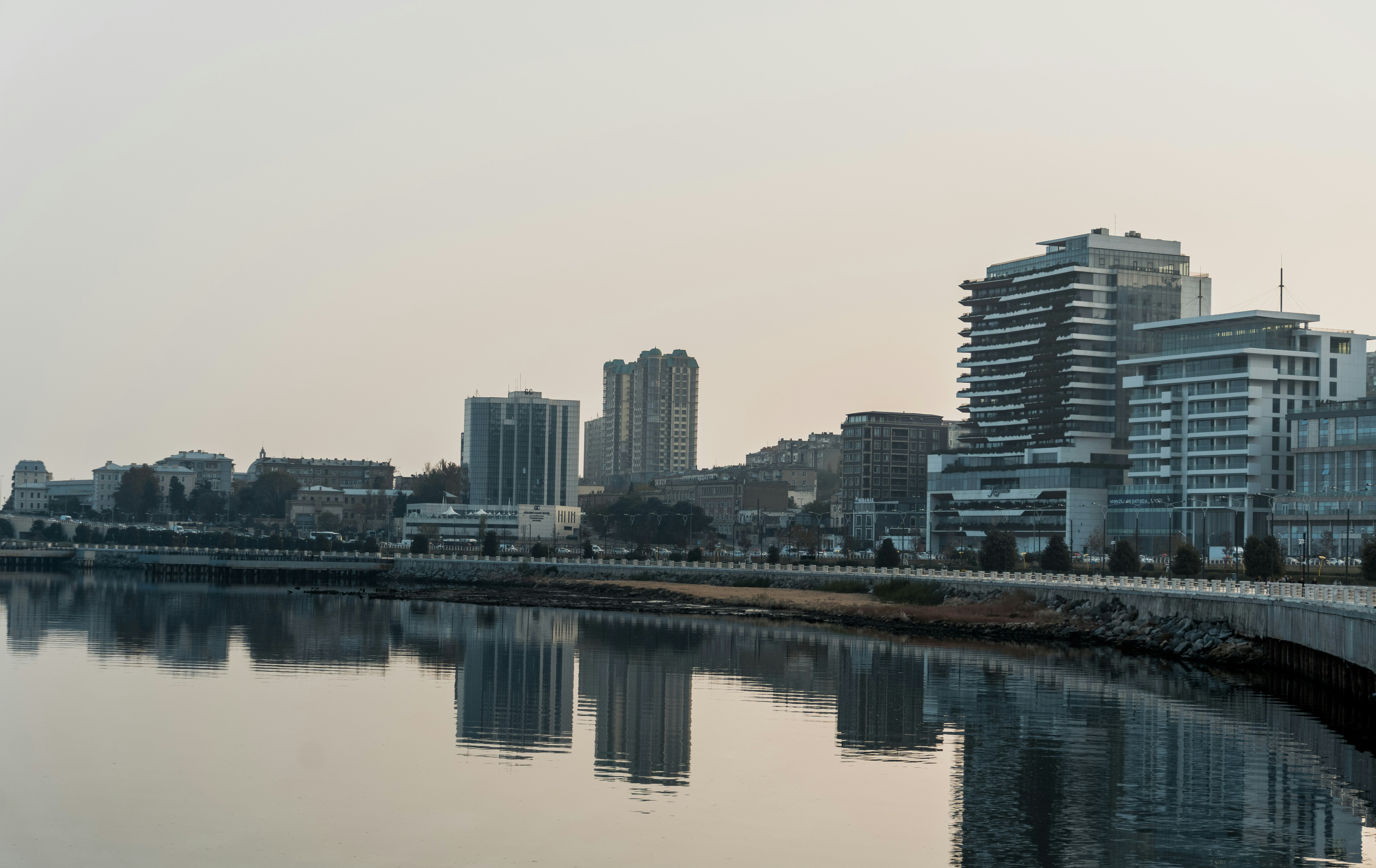City skyline reflected in calm water at dusk