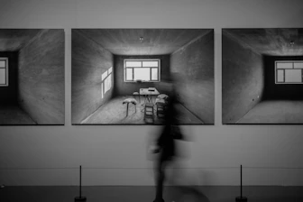 Three framed artworks of an empty room with a table