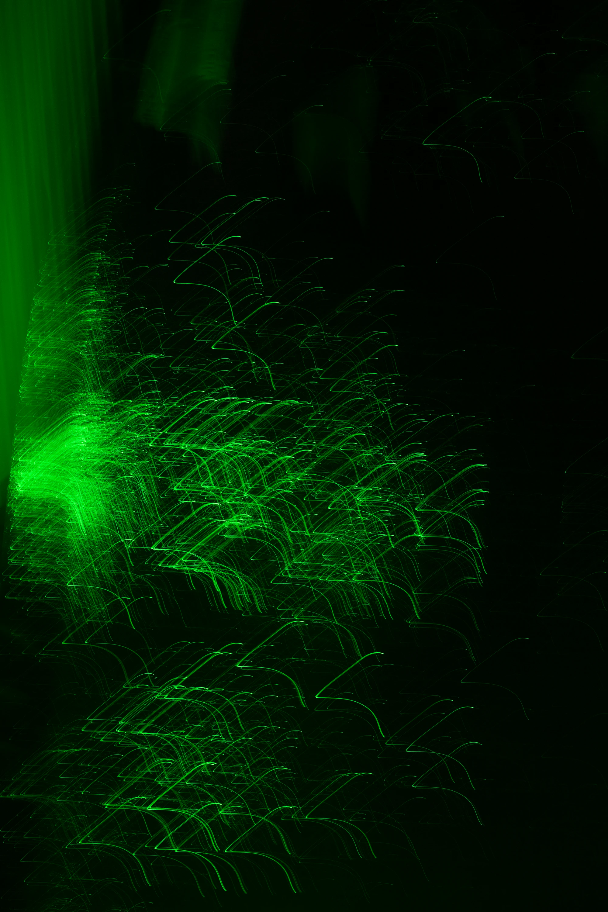 Streaks of bright green light sweeping across a black background