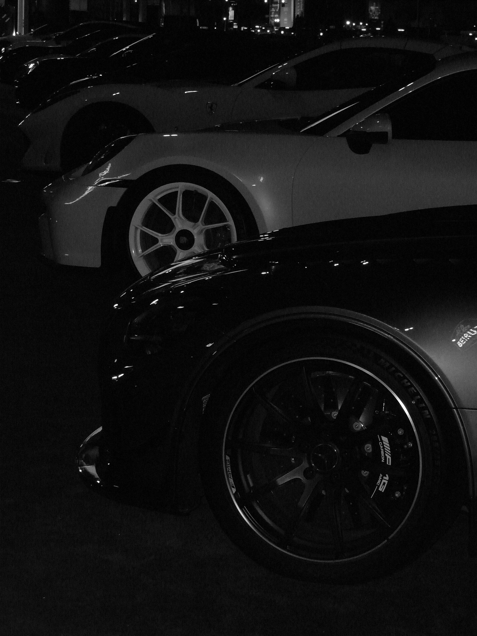 Several sports cars parked in a row at night