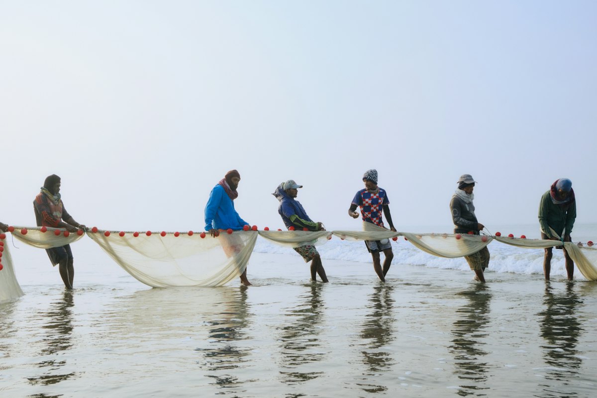 Fishermen pulling nets on the shore