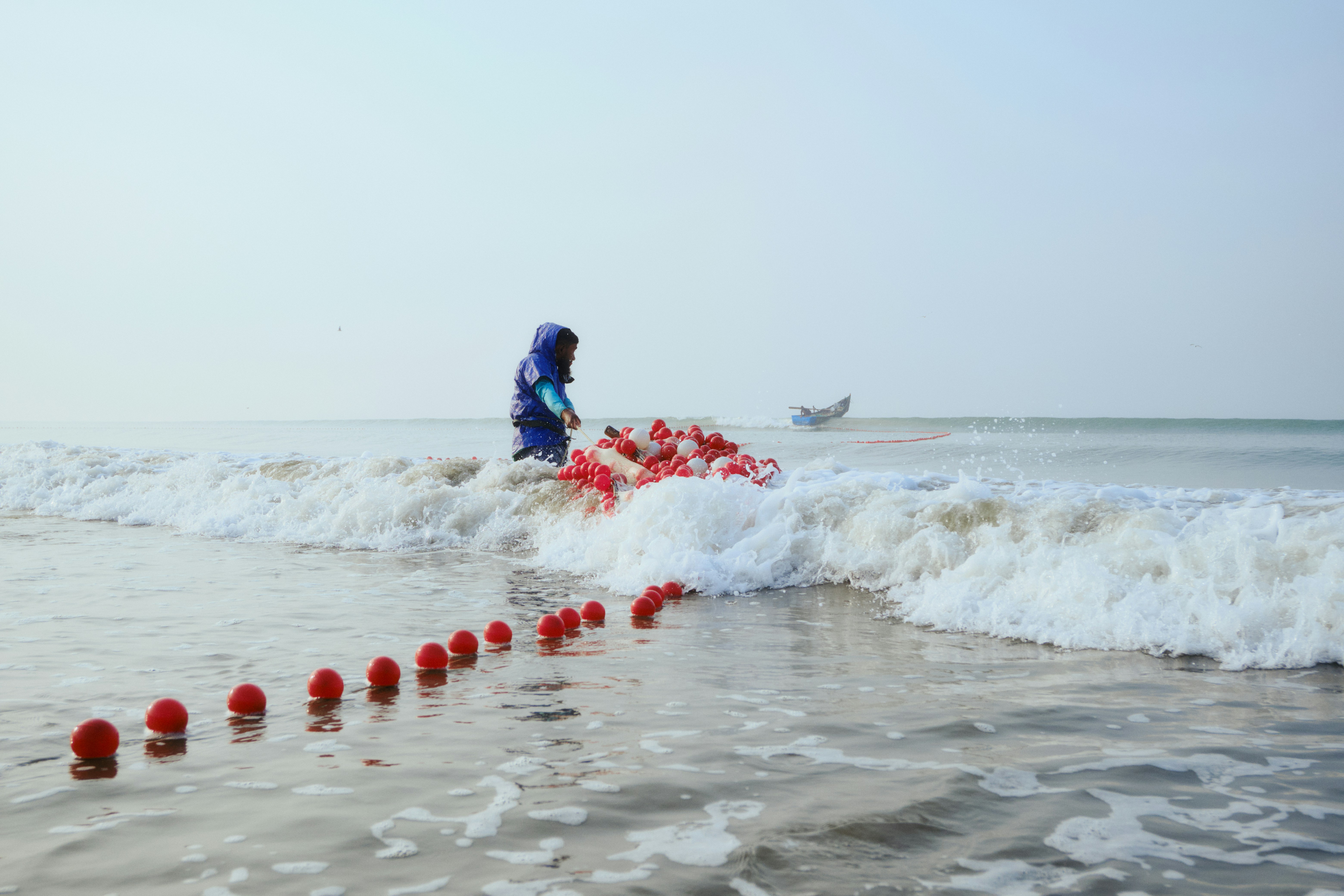 Pescador puxando rede das ondas do oceano