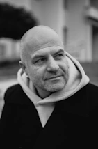 Bald man with beard wearing coat and hoodie
