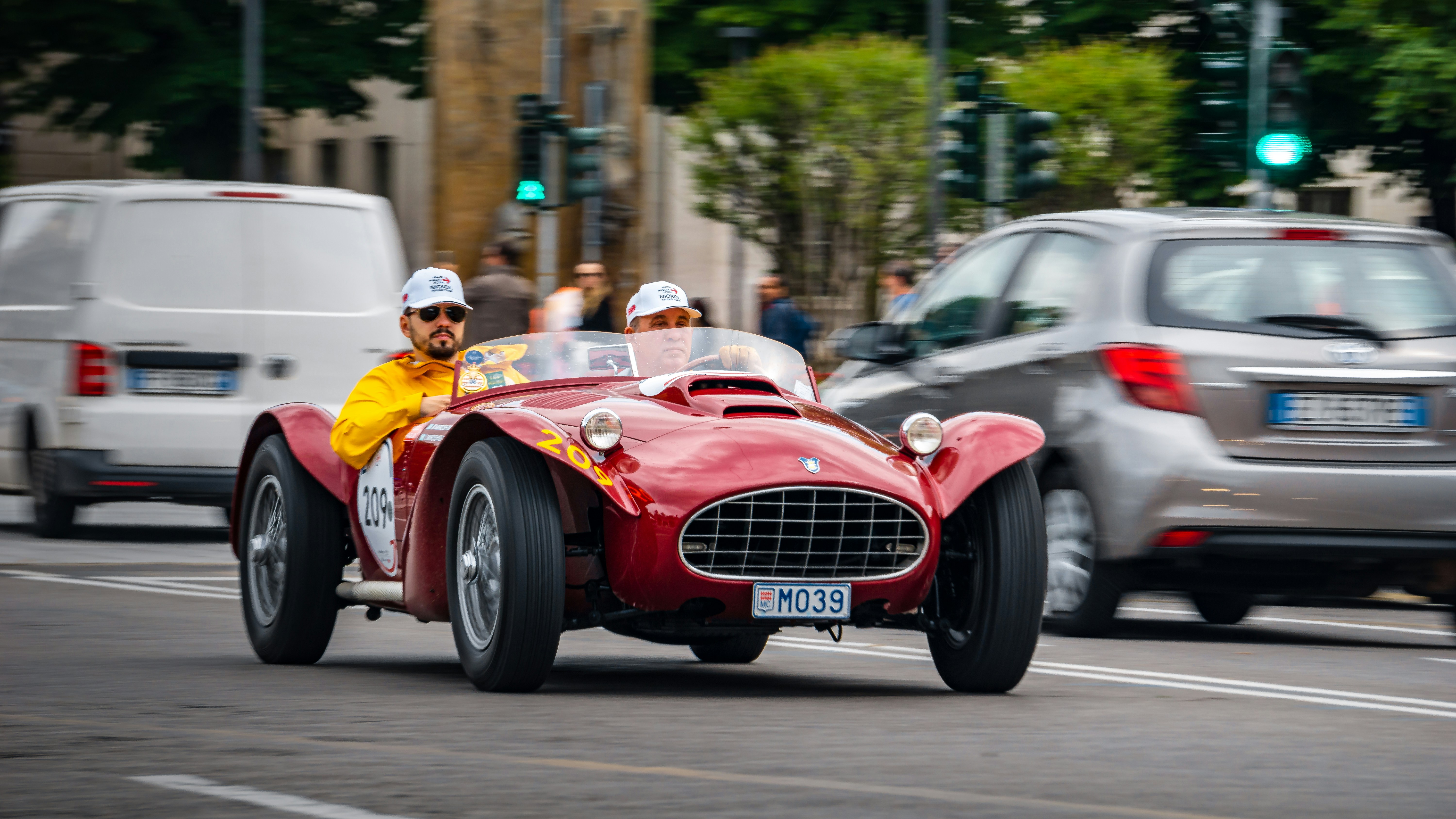 Red vintage race car driving on a city street