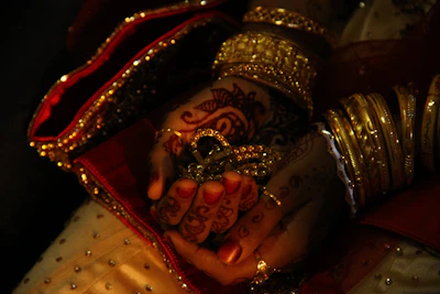 Bride's hands adorned with henna and gold jewelry.