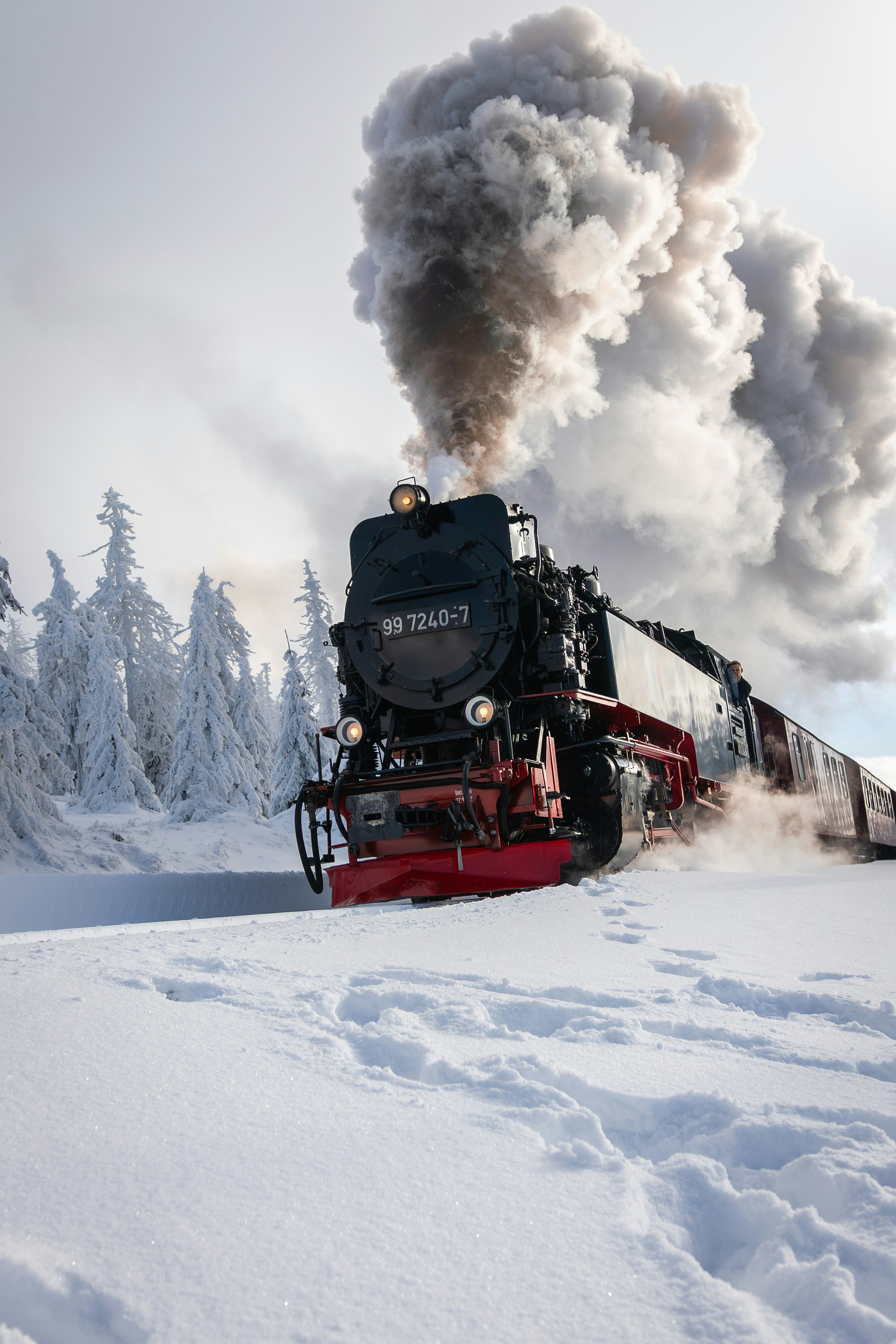 Steam train traveling through a snowy landscape