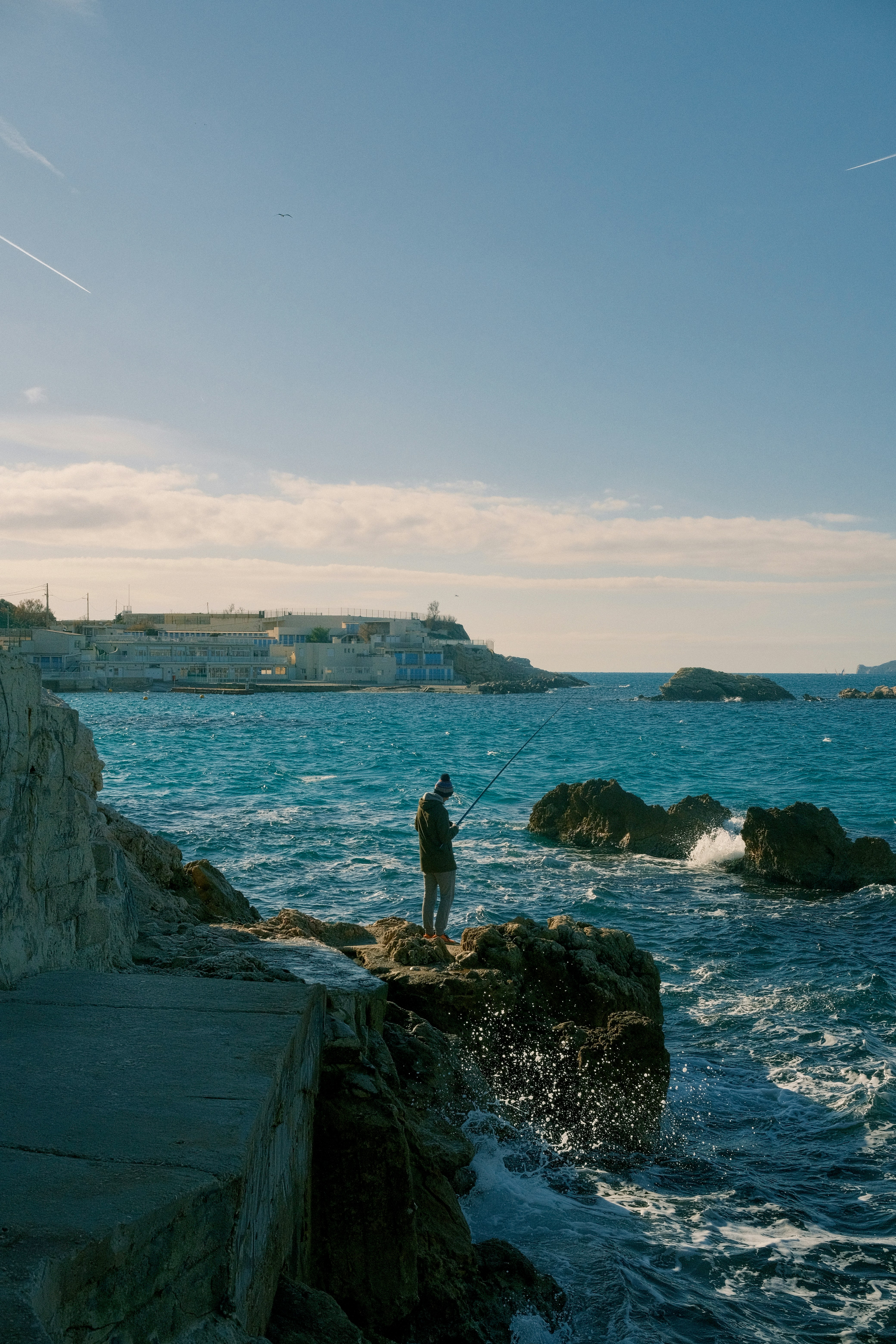 Uomo in piedi sulle rocce vicino all'oceano