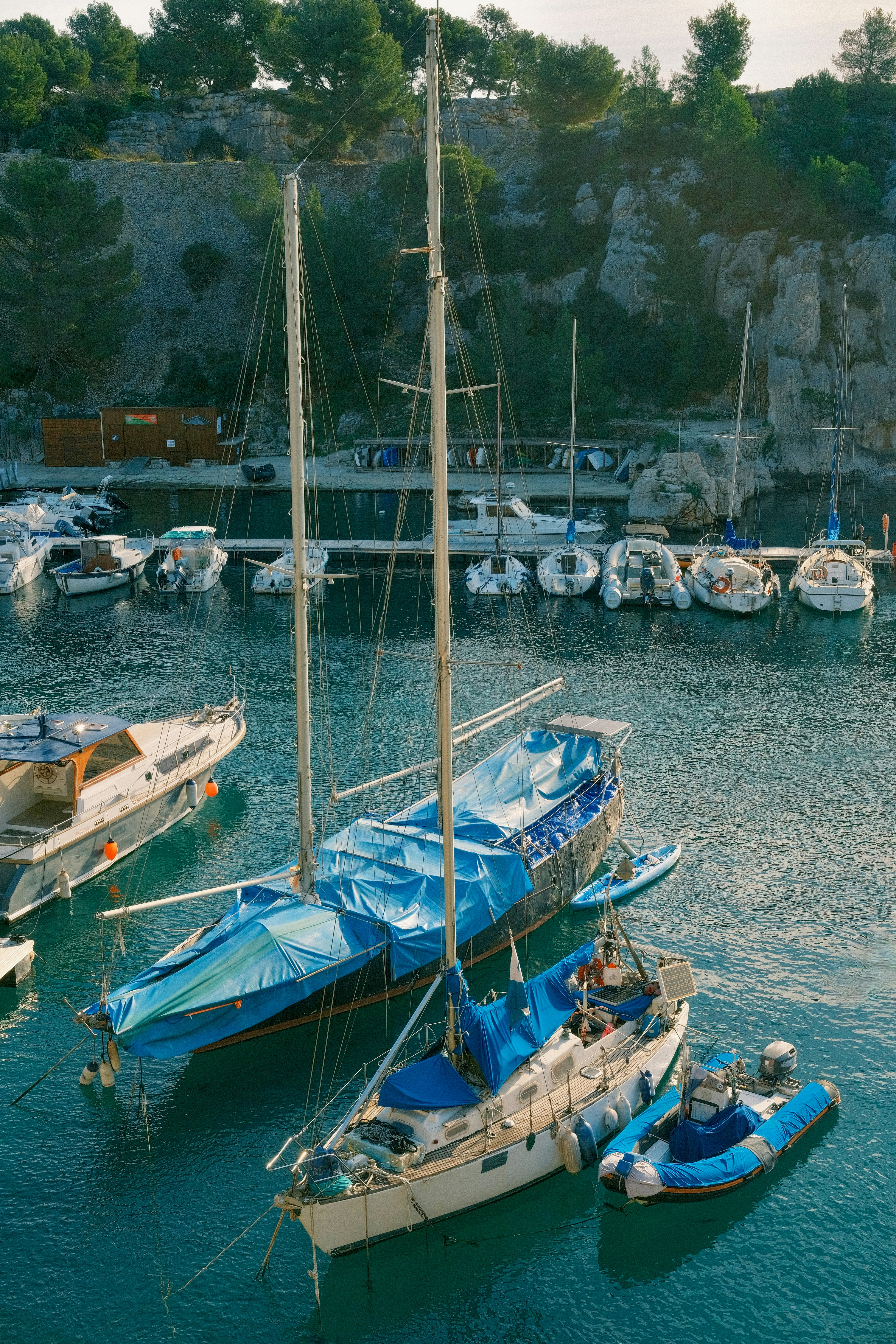 Barche a vela coperte di teli blu in un porto.
