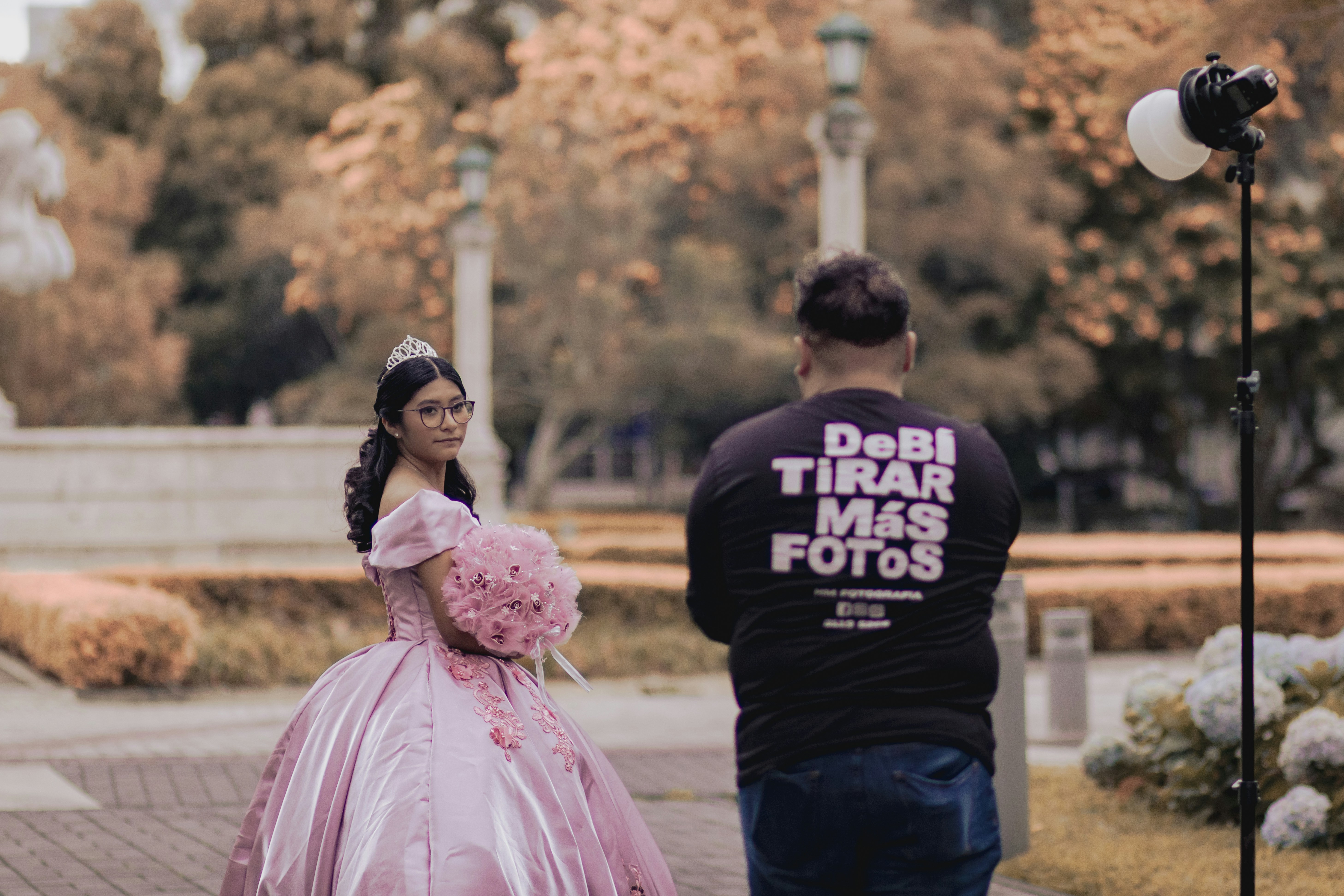 Young woman in pink gown poses for photographer