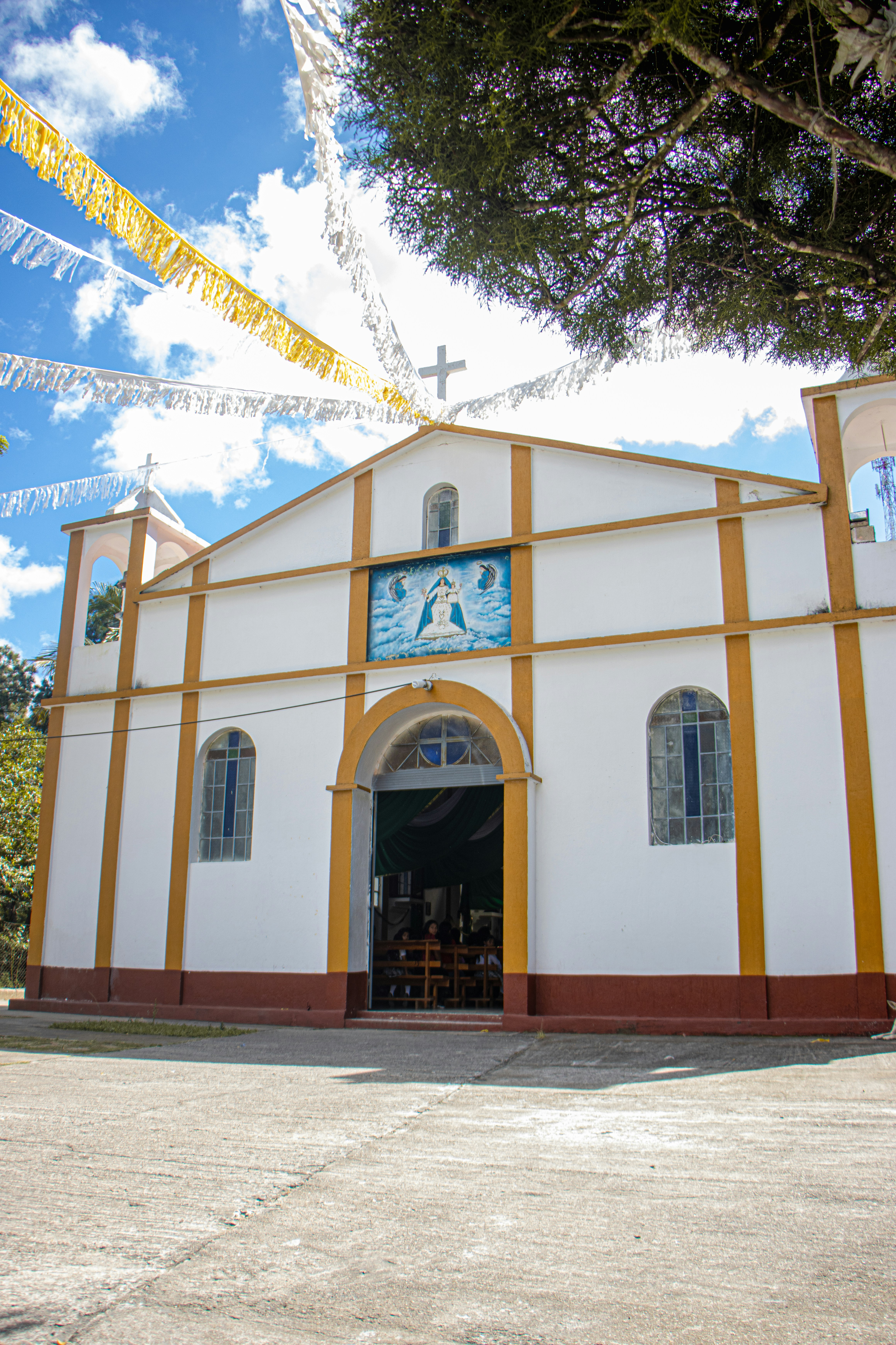 White church with yellow trim and blue sky