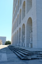 Modern architecture with arched colonnade and statues
