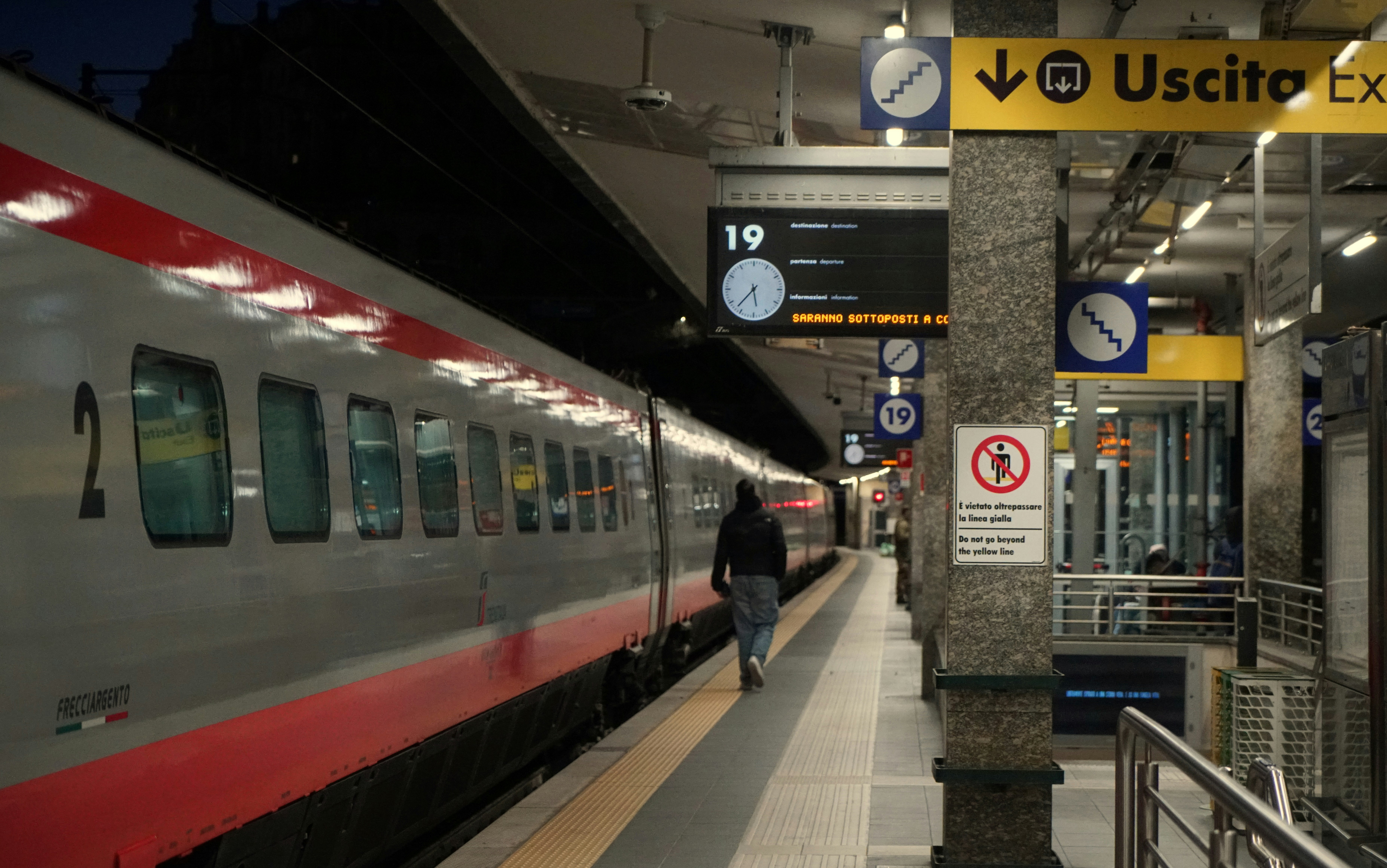 Trem em uma plataforma de estação com placa de saída