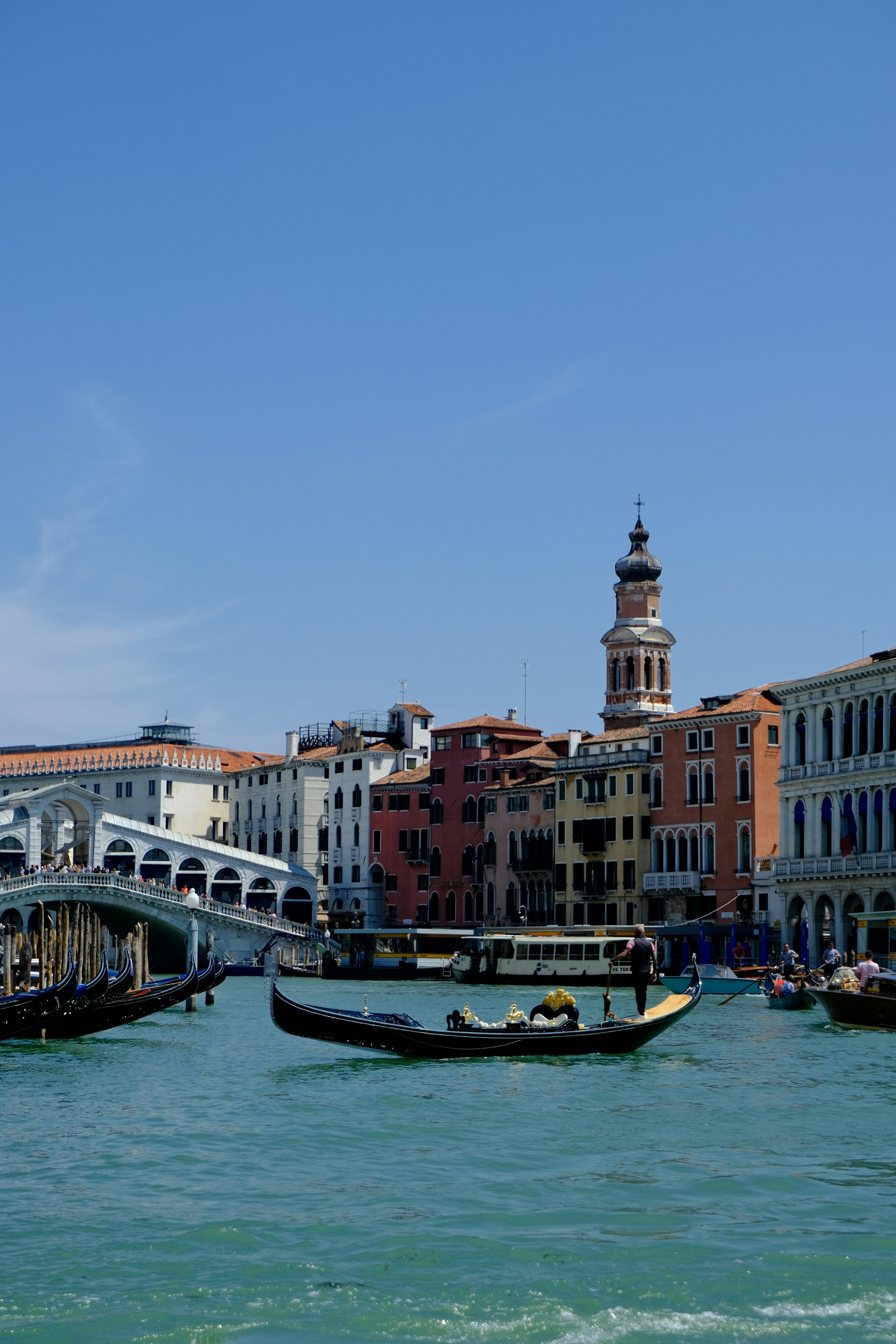 Gondola on canal with rialto bridge in venice.