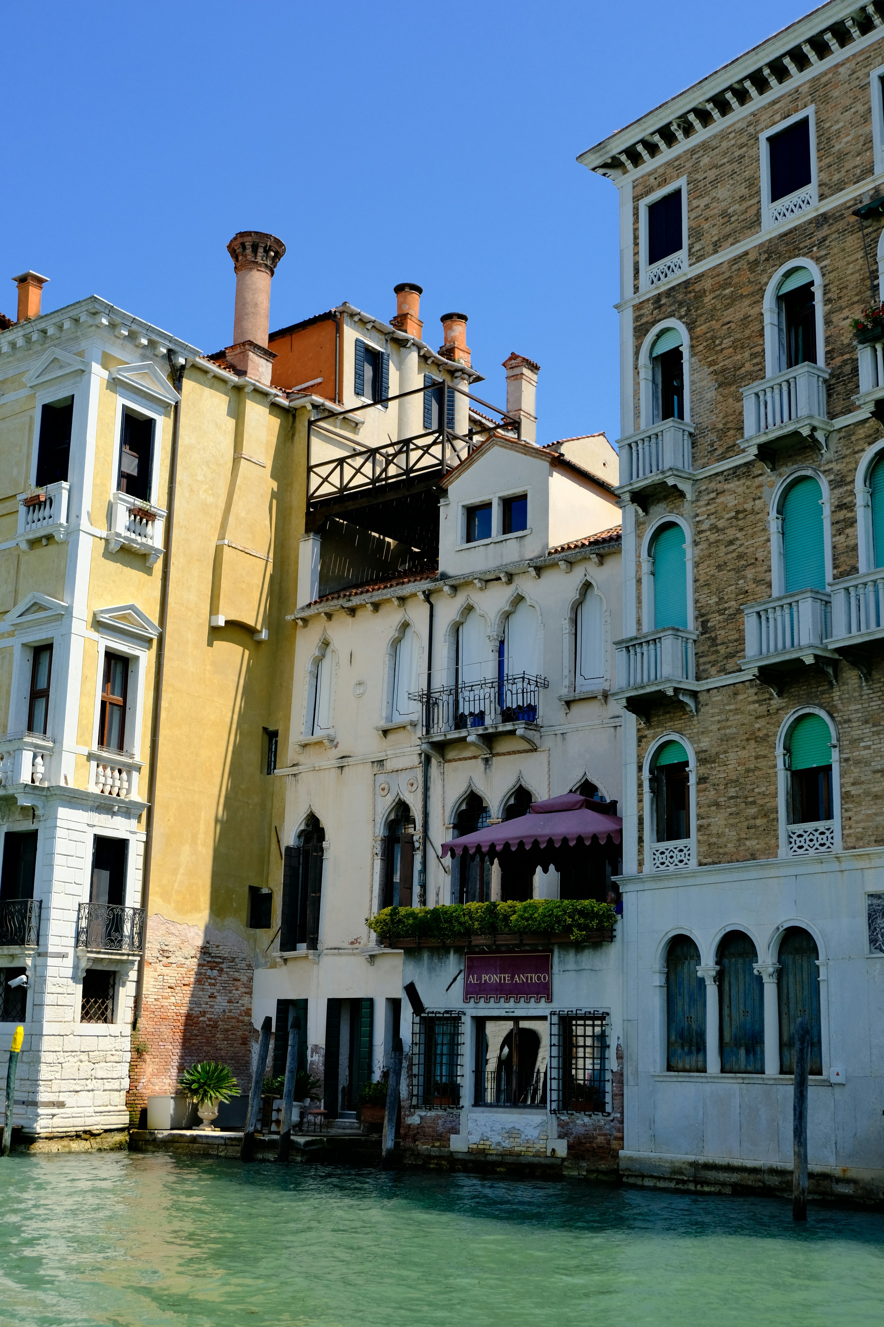 Buildings line a canal in venice under a clear sky.