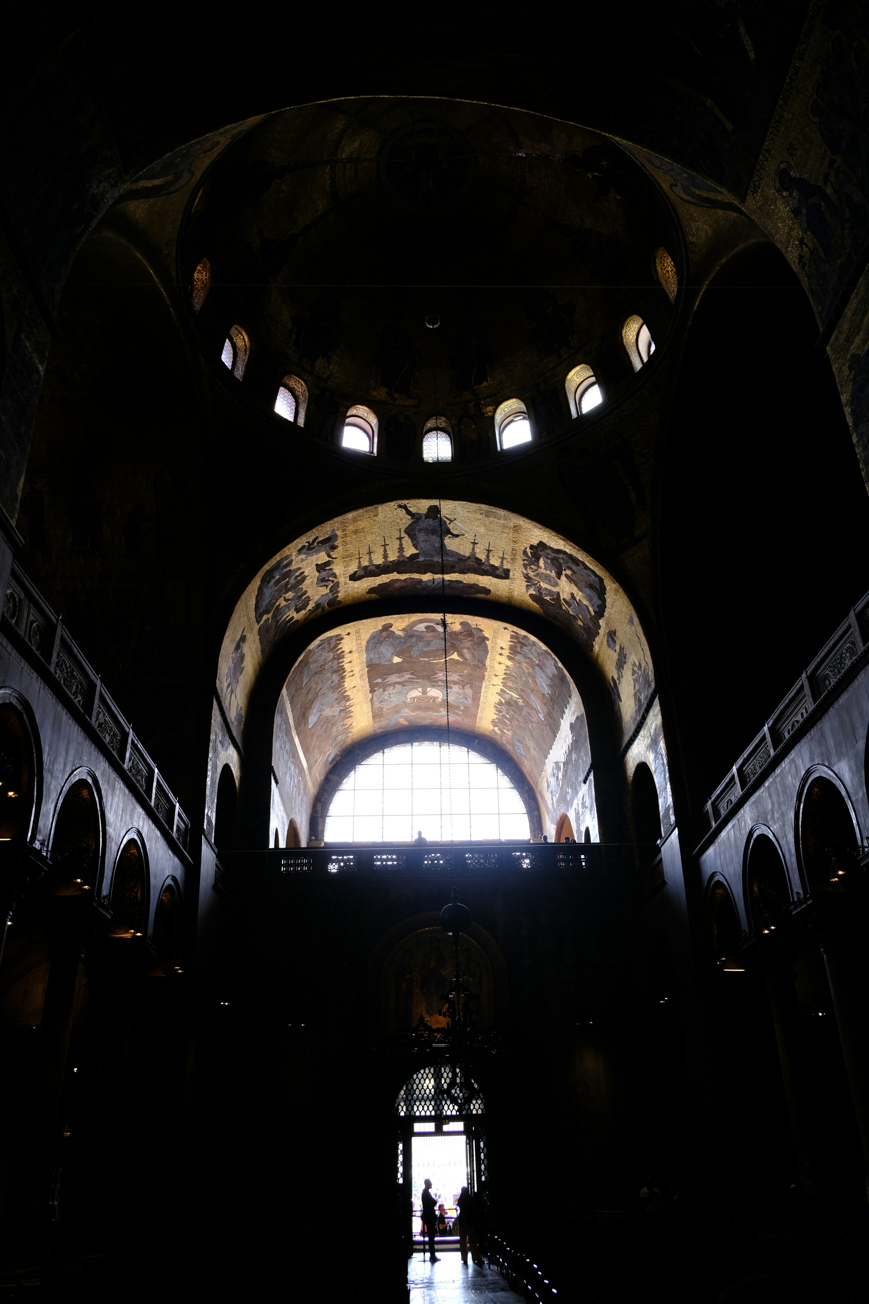 Interior of a grand cathedral with ornate mosaics and arches.