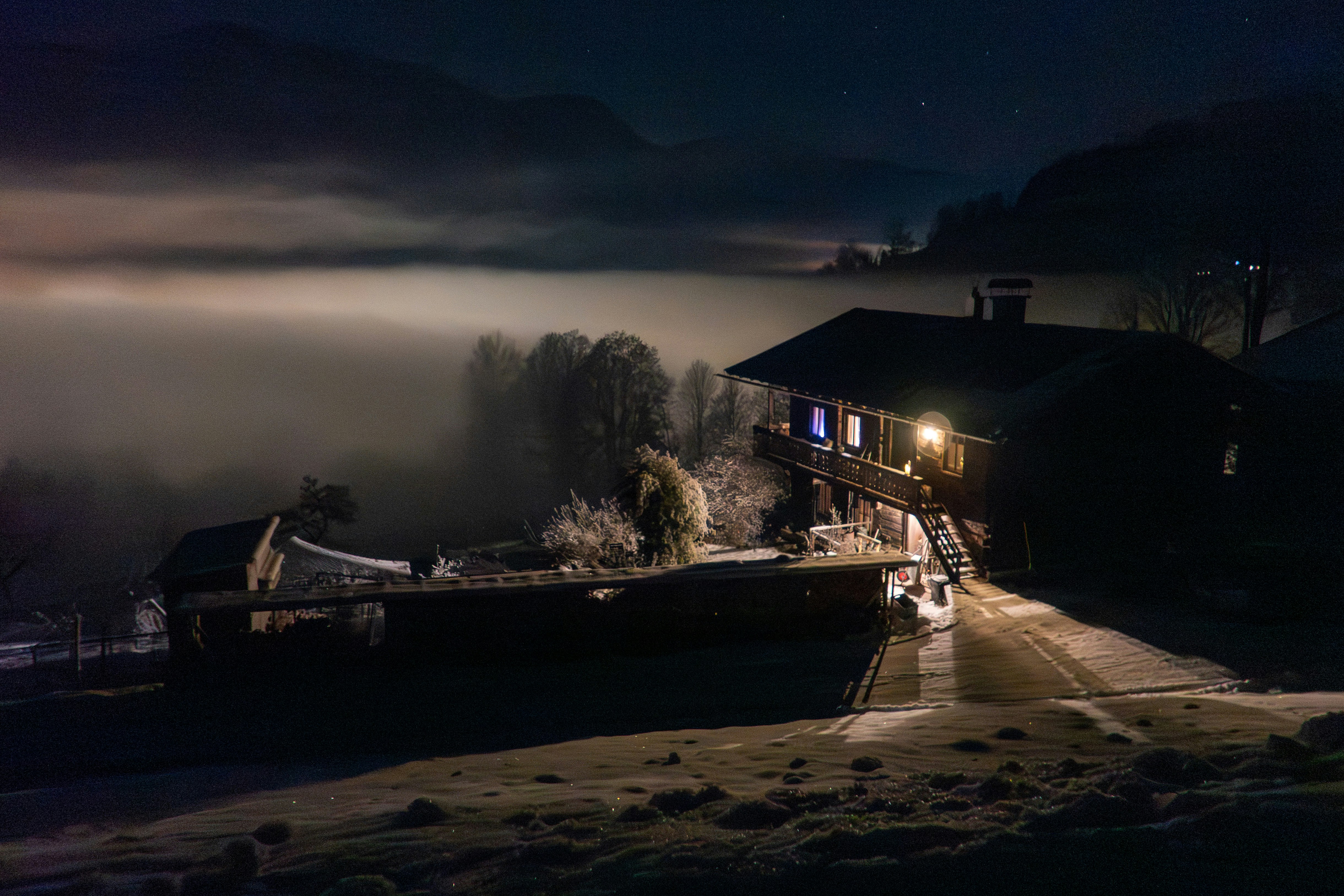 Una casa rústica en la niebla por la noche.