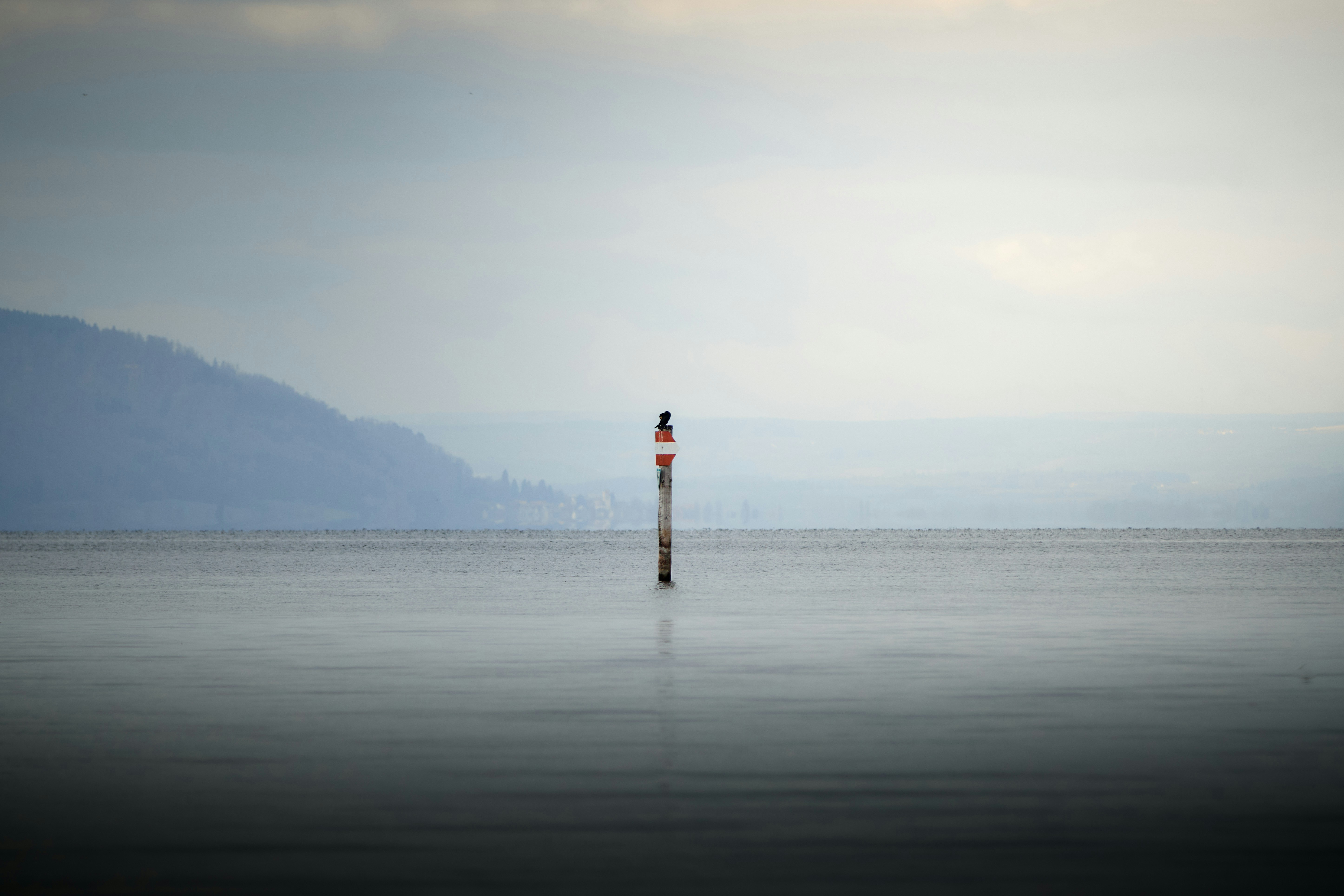 Buoy in the calm water with mountains in background