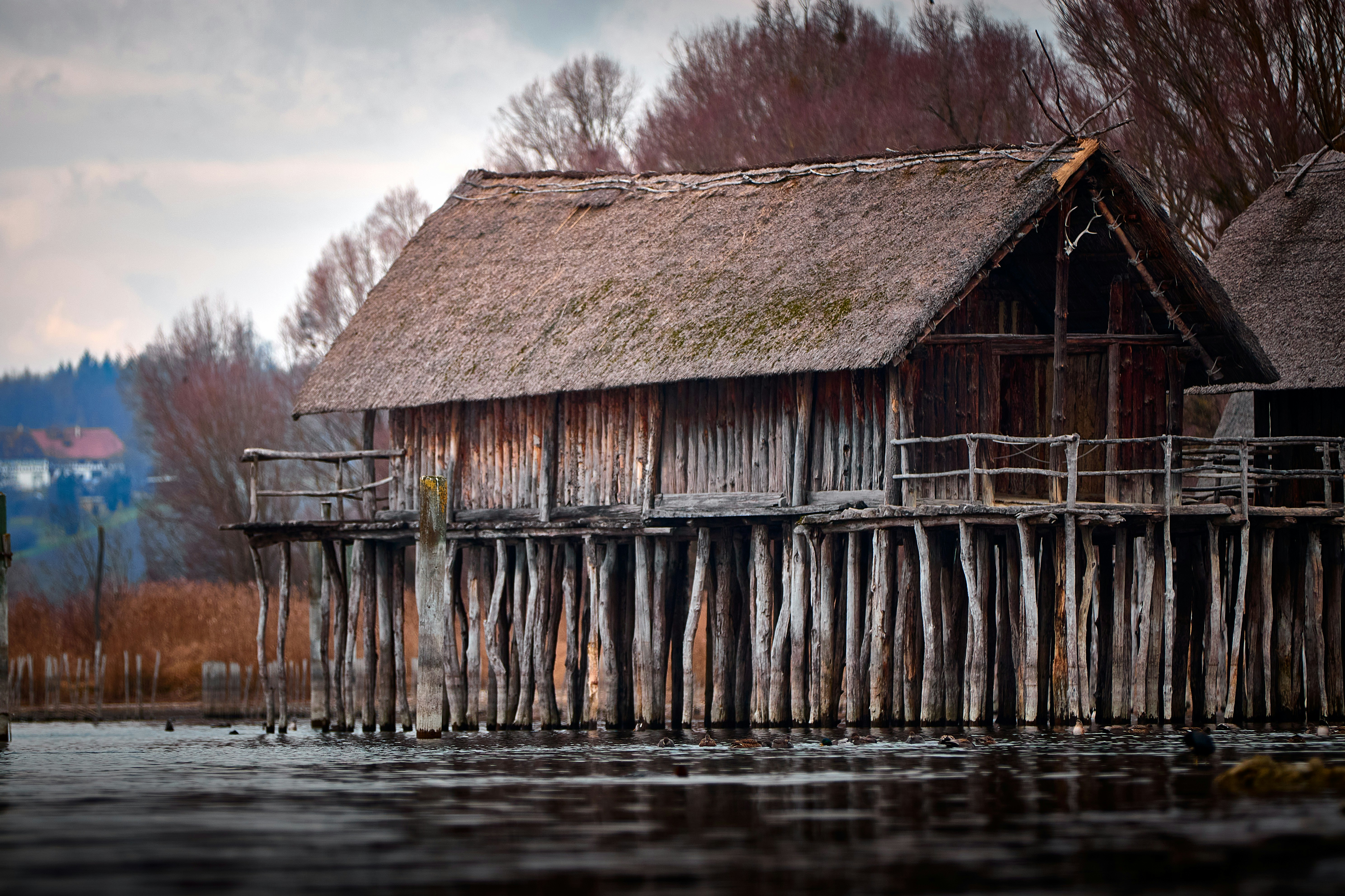 Wooden stilt houses on a lake at dusk.