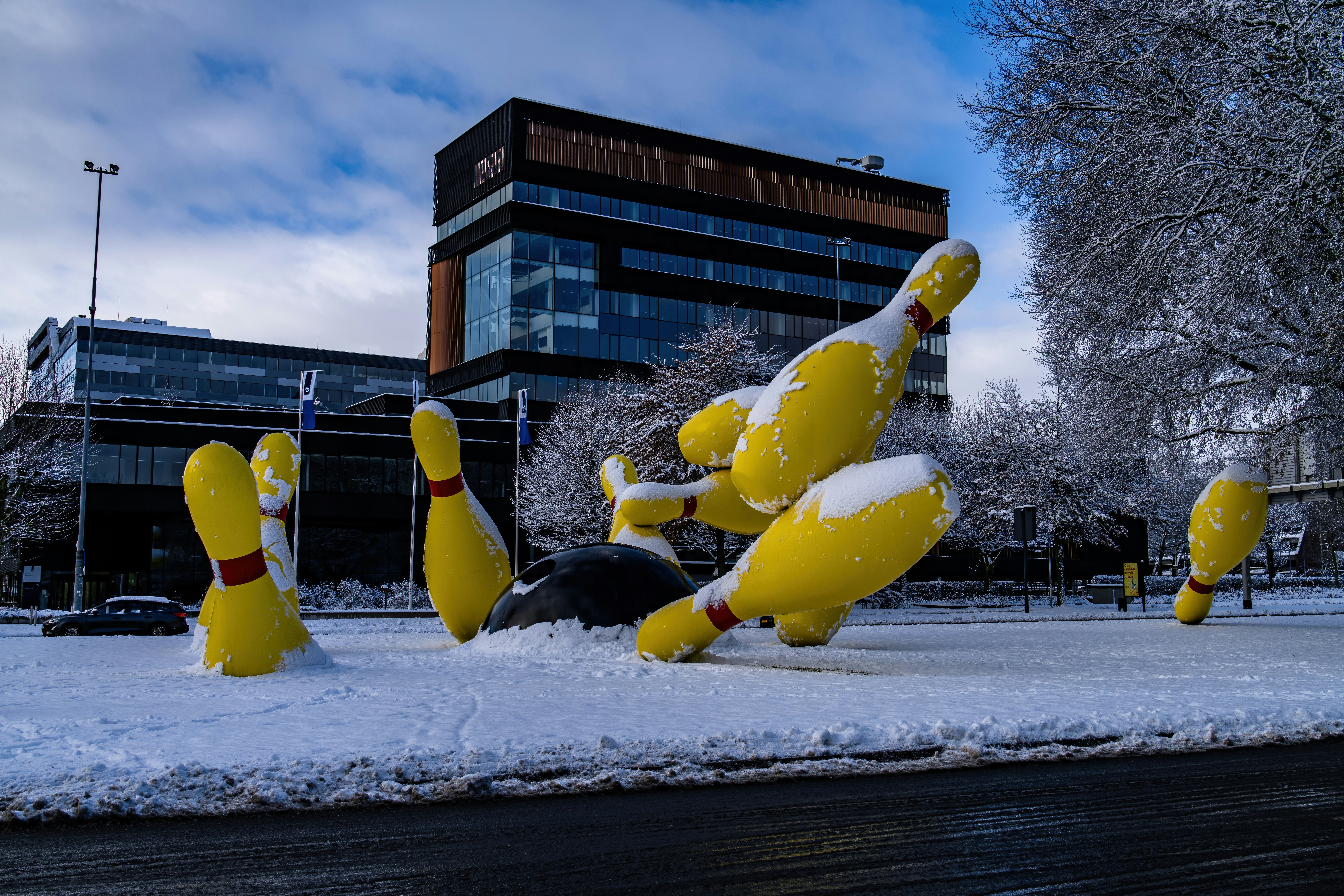 Giant yellow bowling pins covered in snow
