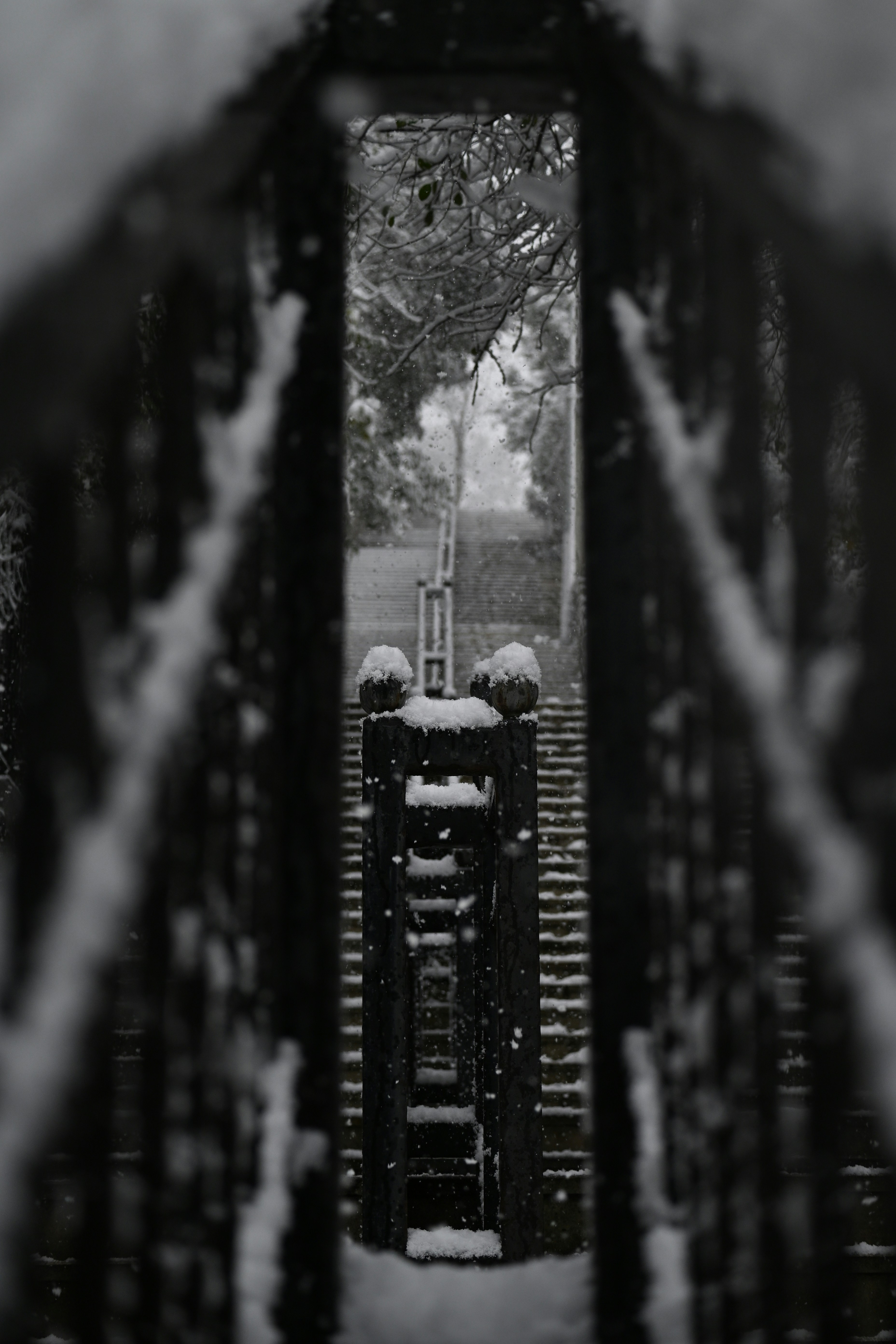 Snow-covered monument viewed through a fence