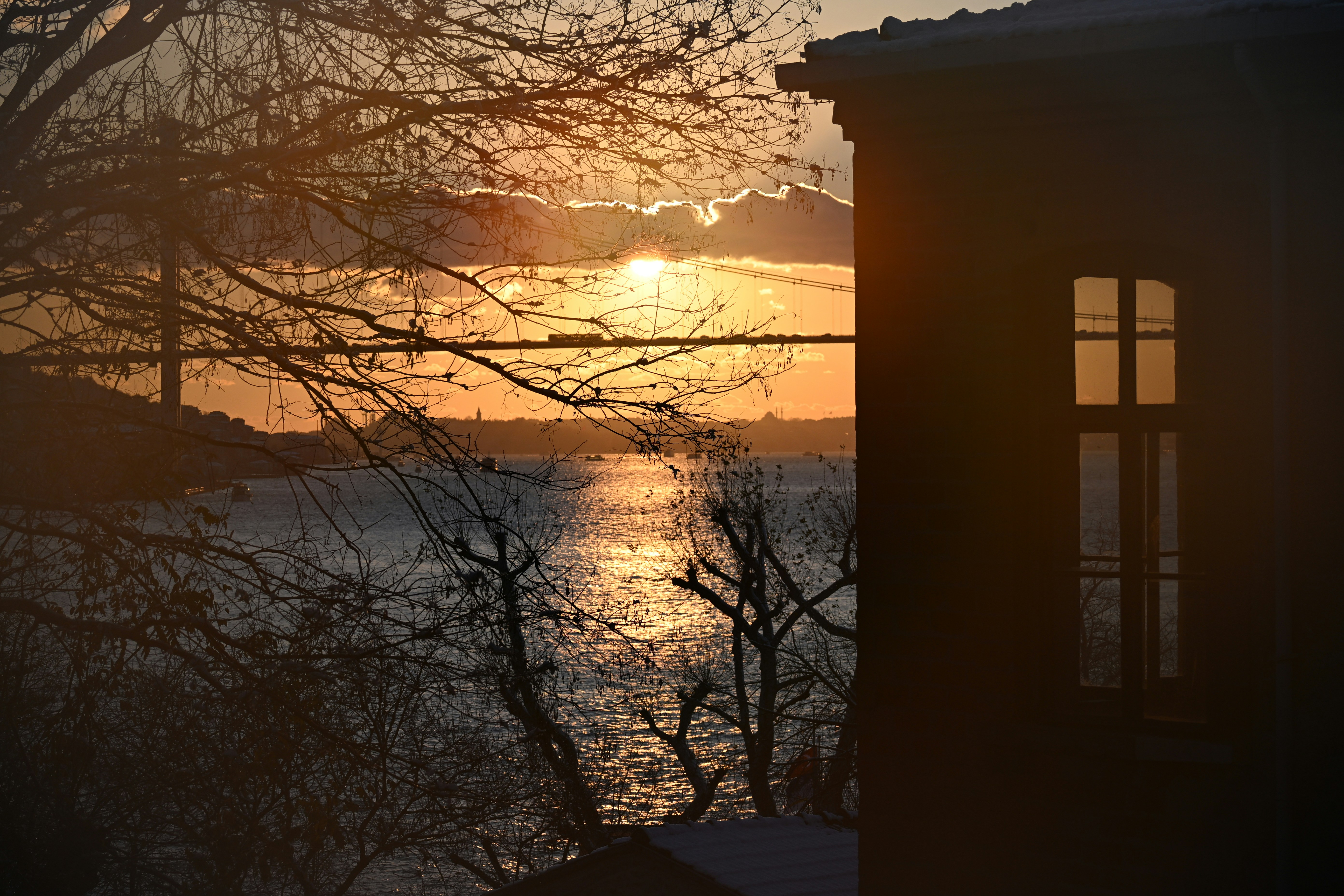 Sunset over water with a silhouetted building.