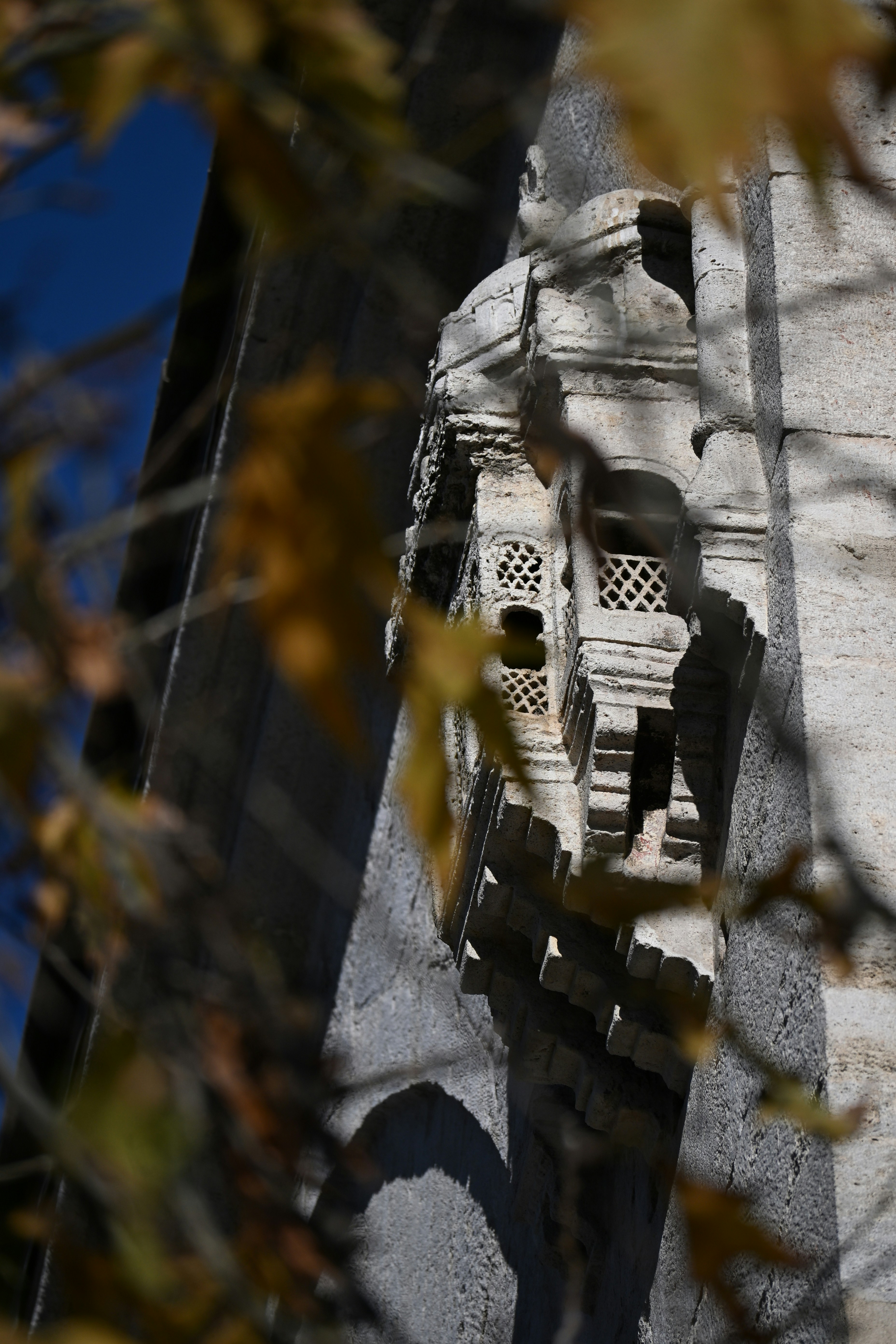 Ornate architectural detail with autumn leaves in foreground