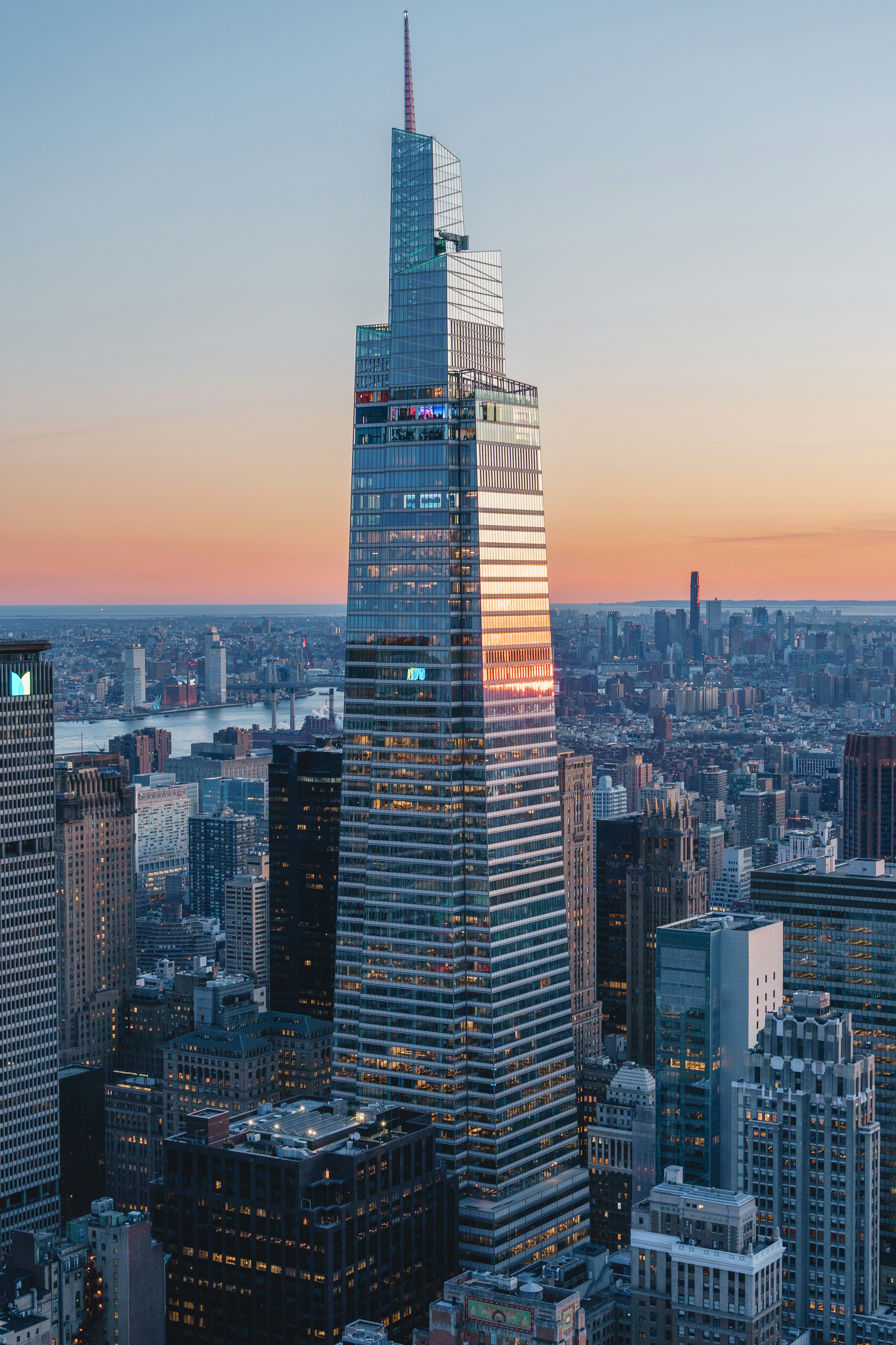 Modern skyscraper against a sunset sky in a city.
