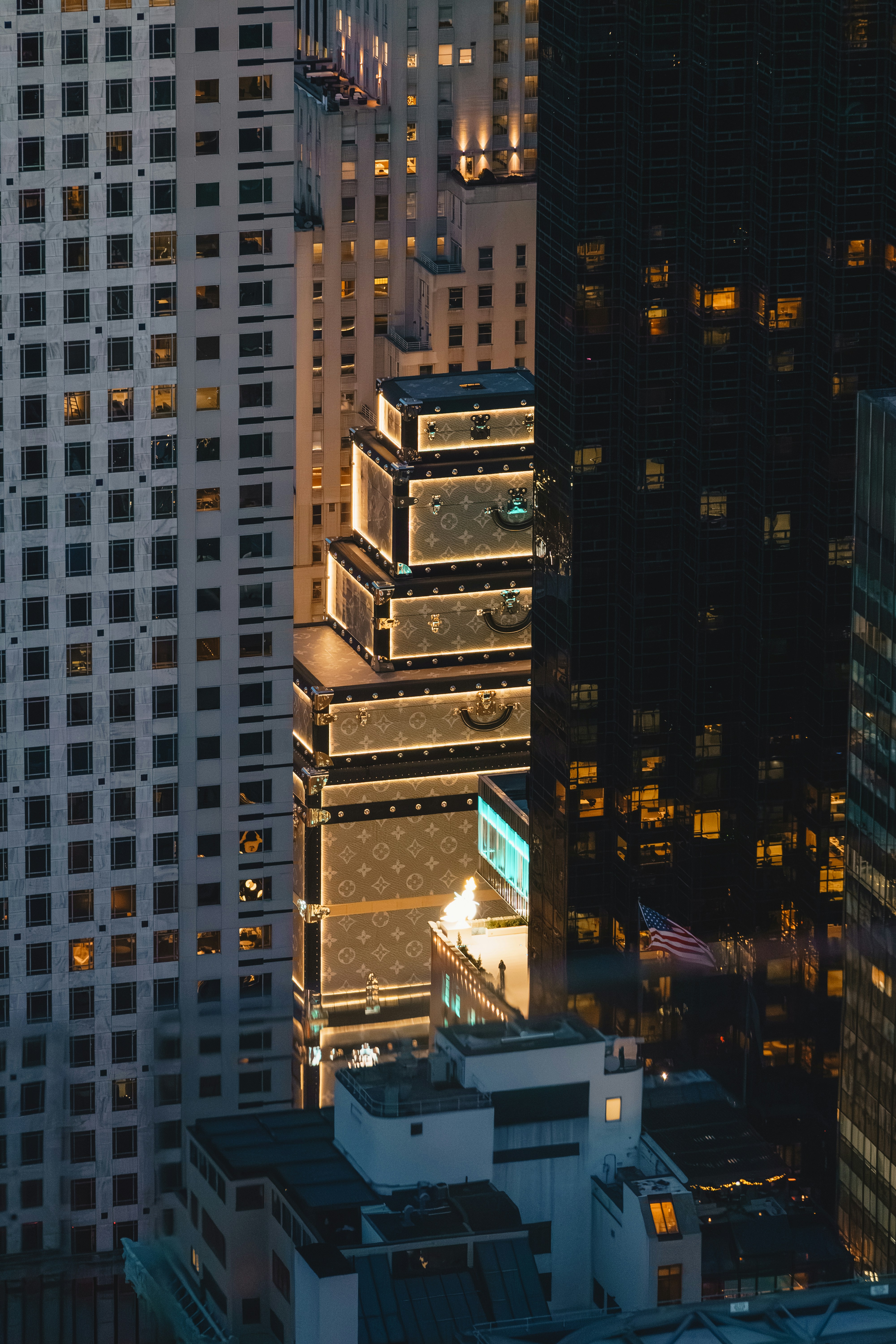 Tall buildings illuminated at dusk in a city.