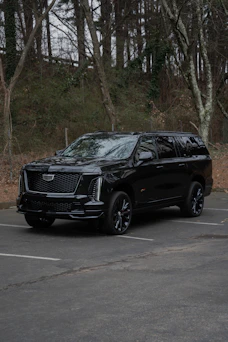 A black cadillac escalade parked in a lot