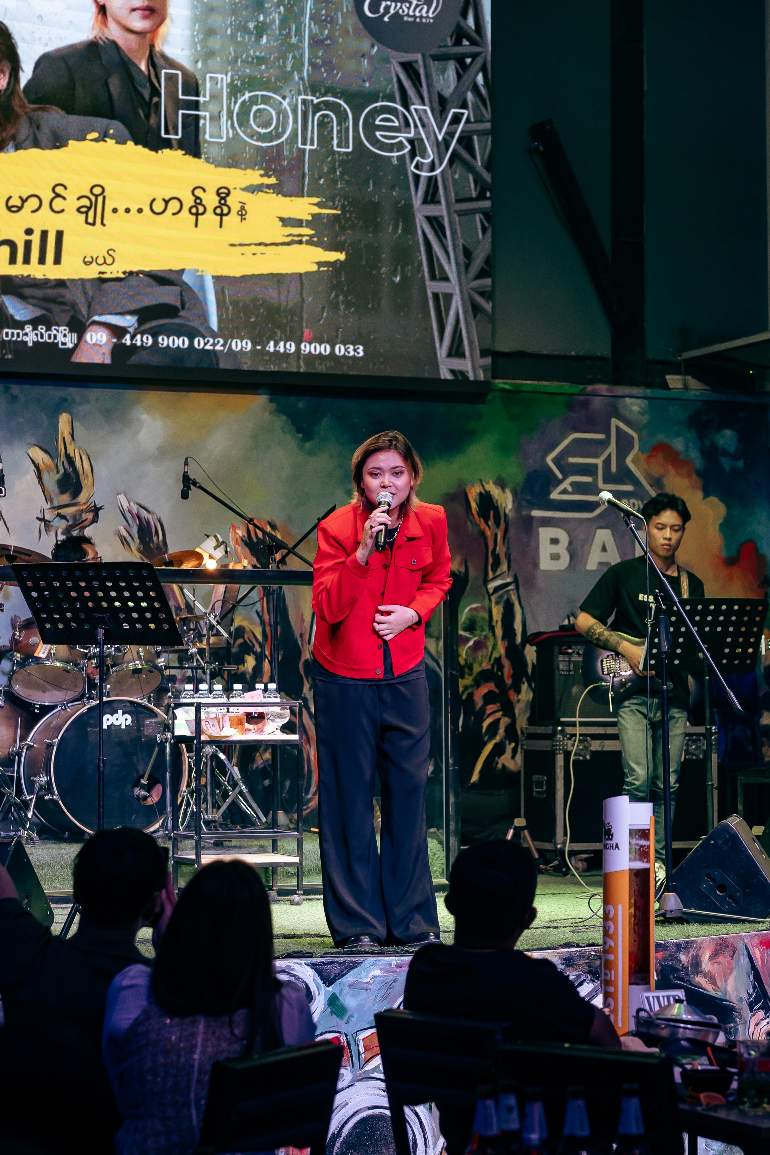 Mujer cantando en el escenario con la banda actuando en directo