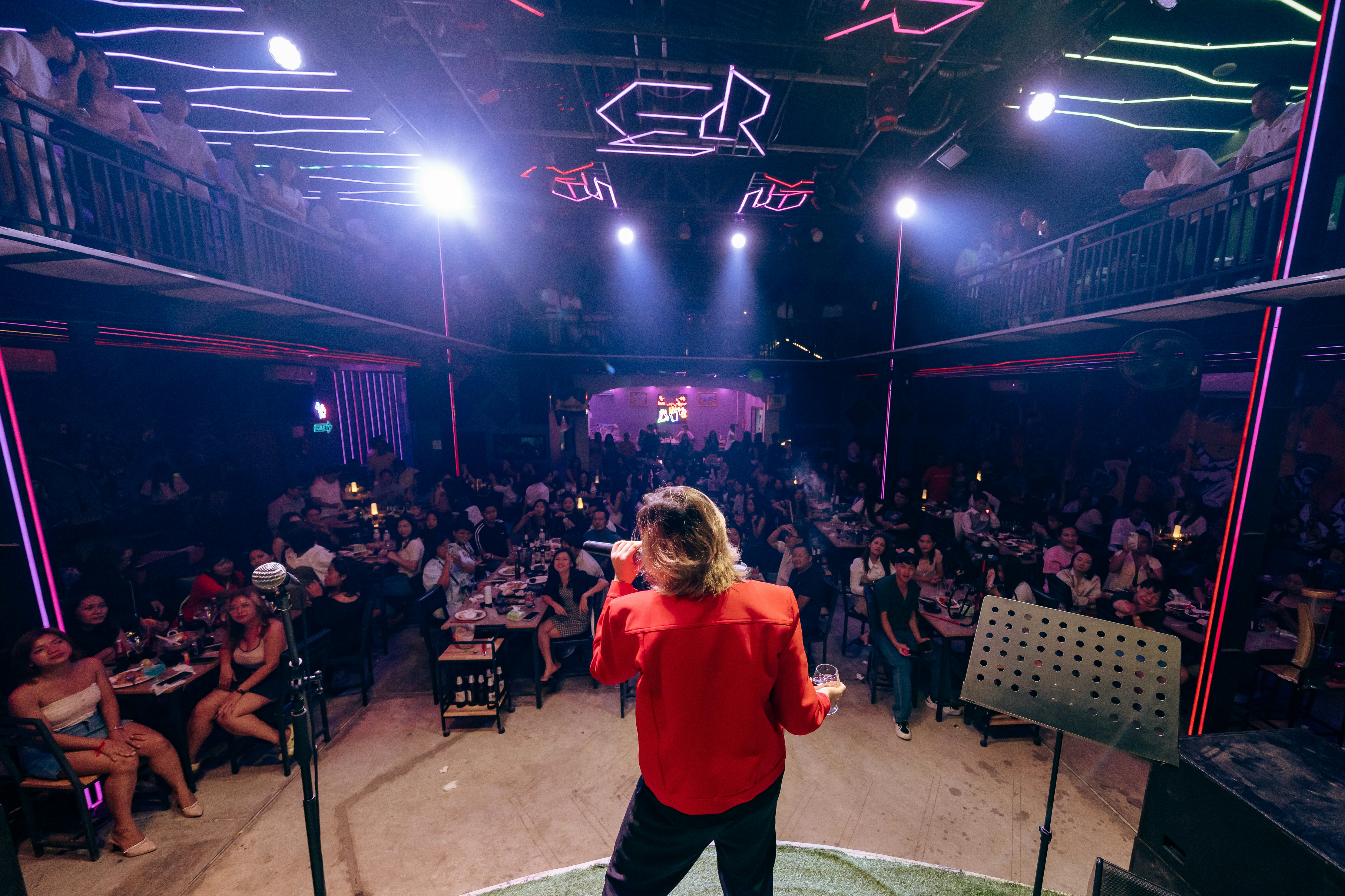 Singer performing on stage for a large audience.