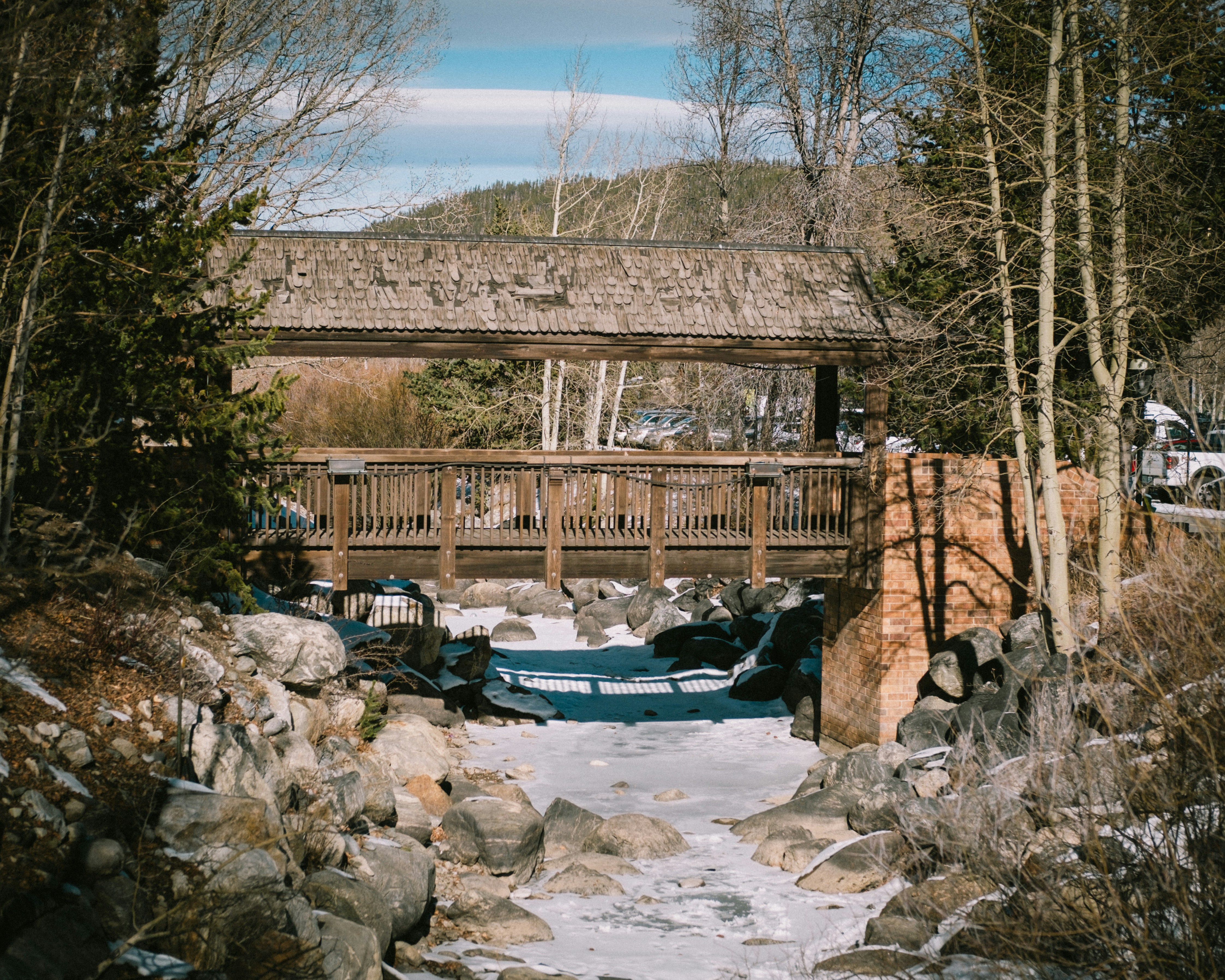Wooden bridge over a frozen stream in winter