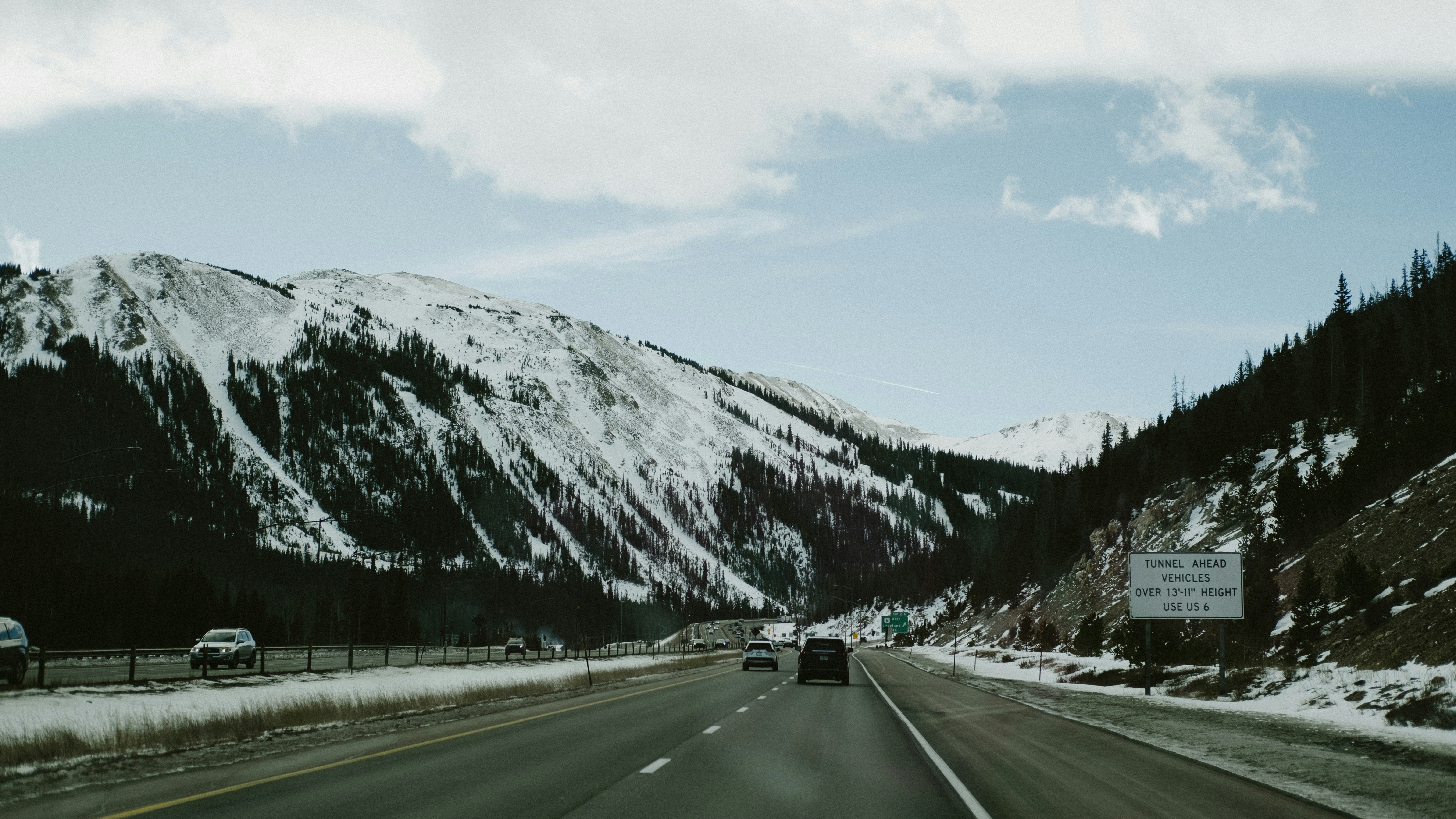 Driving on a highway through snowy mountains.