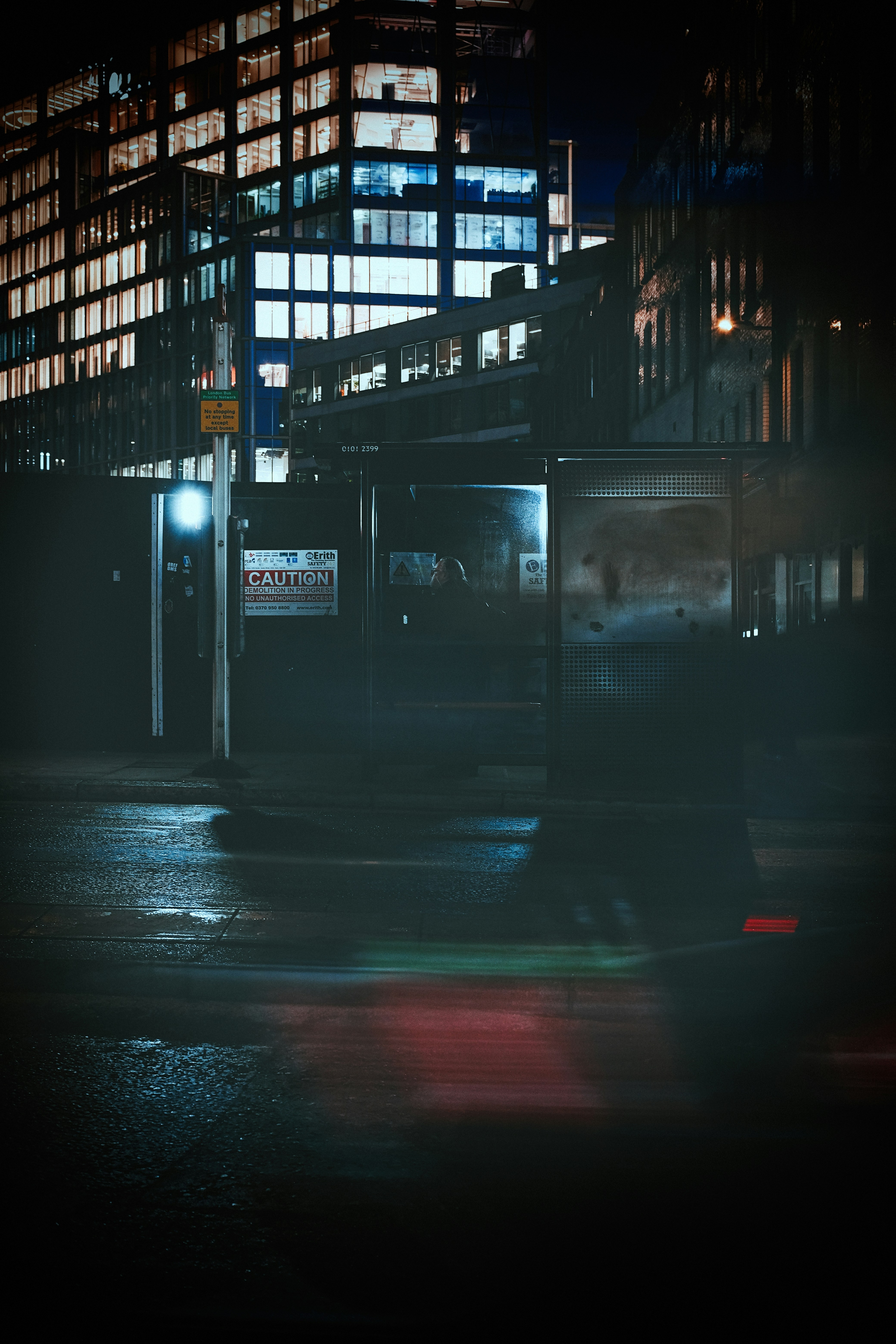 City street at night with wet pavement and lights.