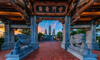 Ancient pagodas viewed through a stone archway at sunset