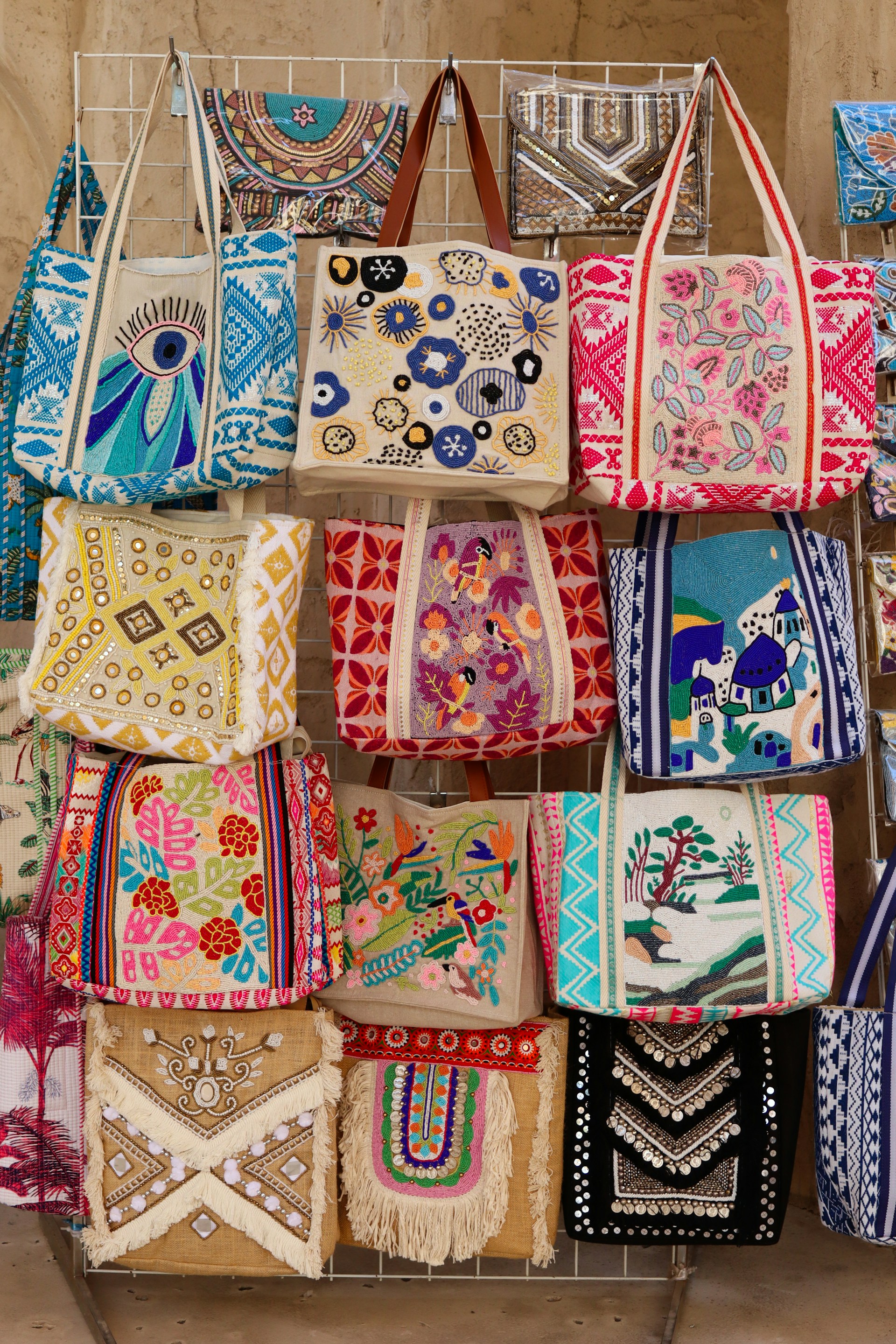 Display of colorful embroidered bags with various patterns.