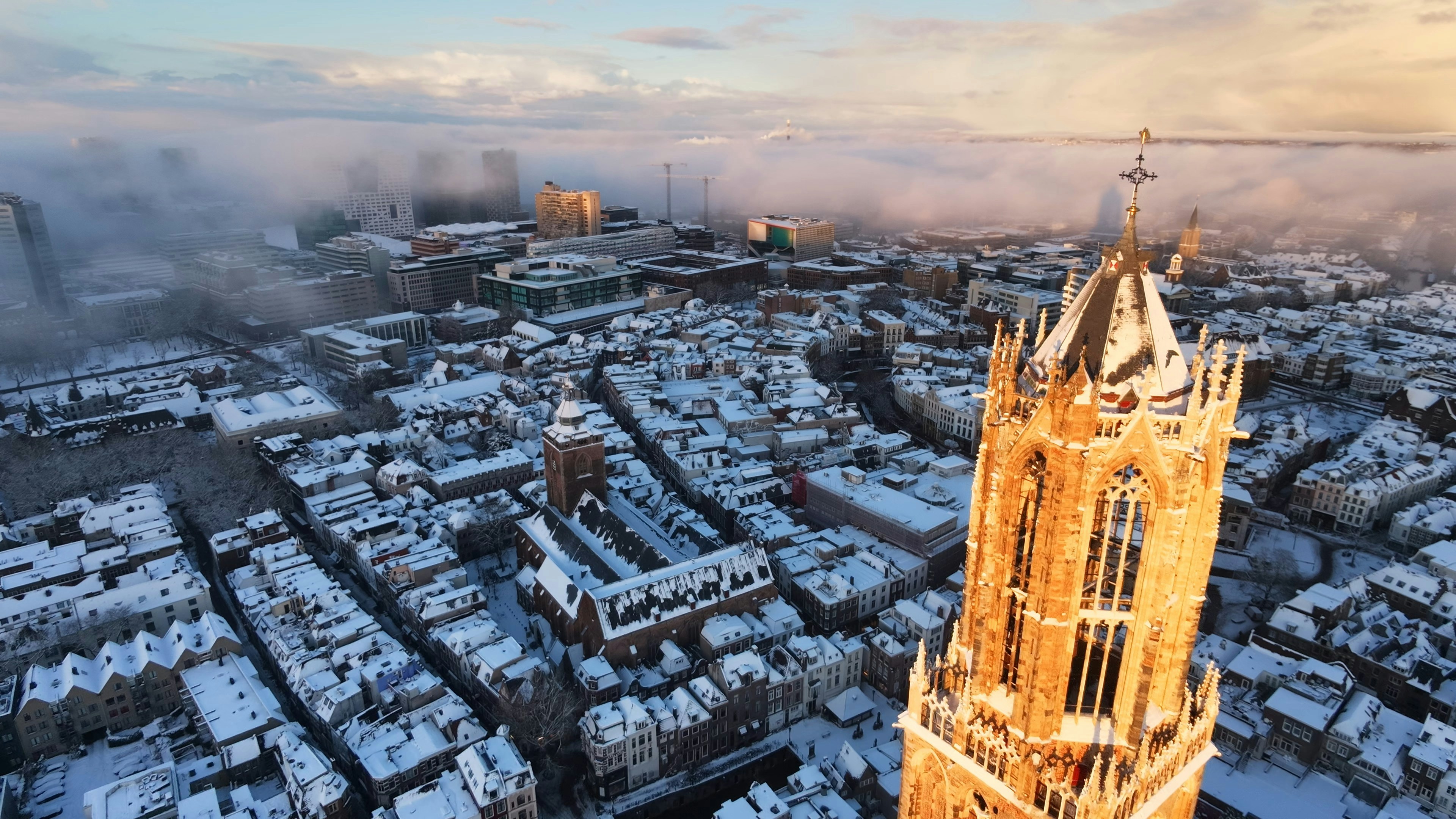 Snow-covered city with a tall church tower