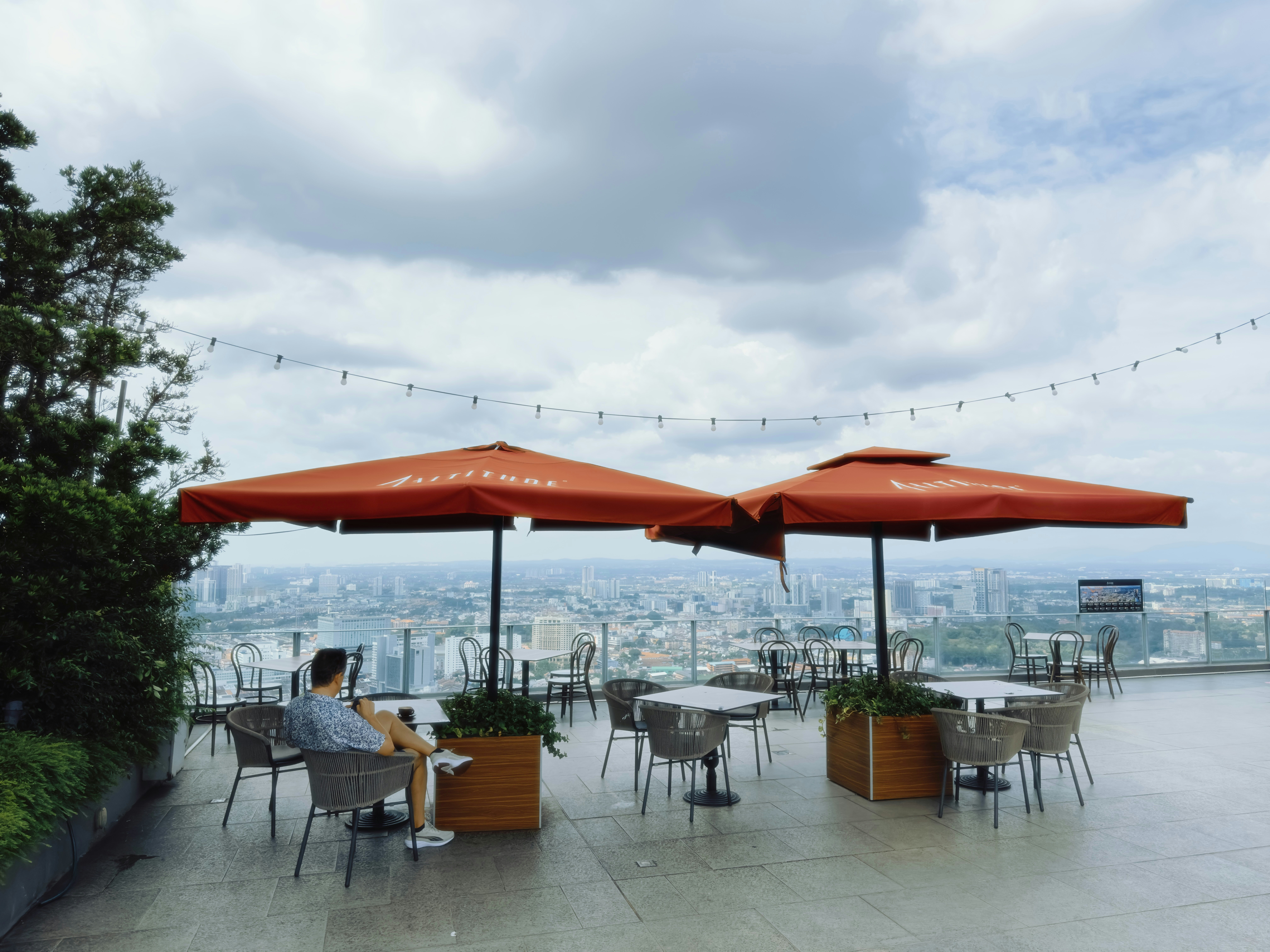 Outdoor cafe seating with city view under umbrellas