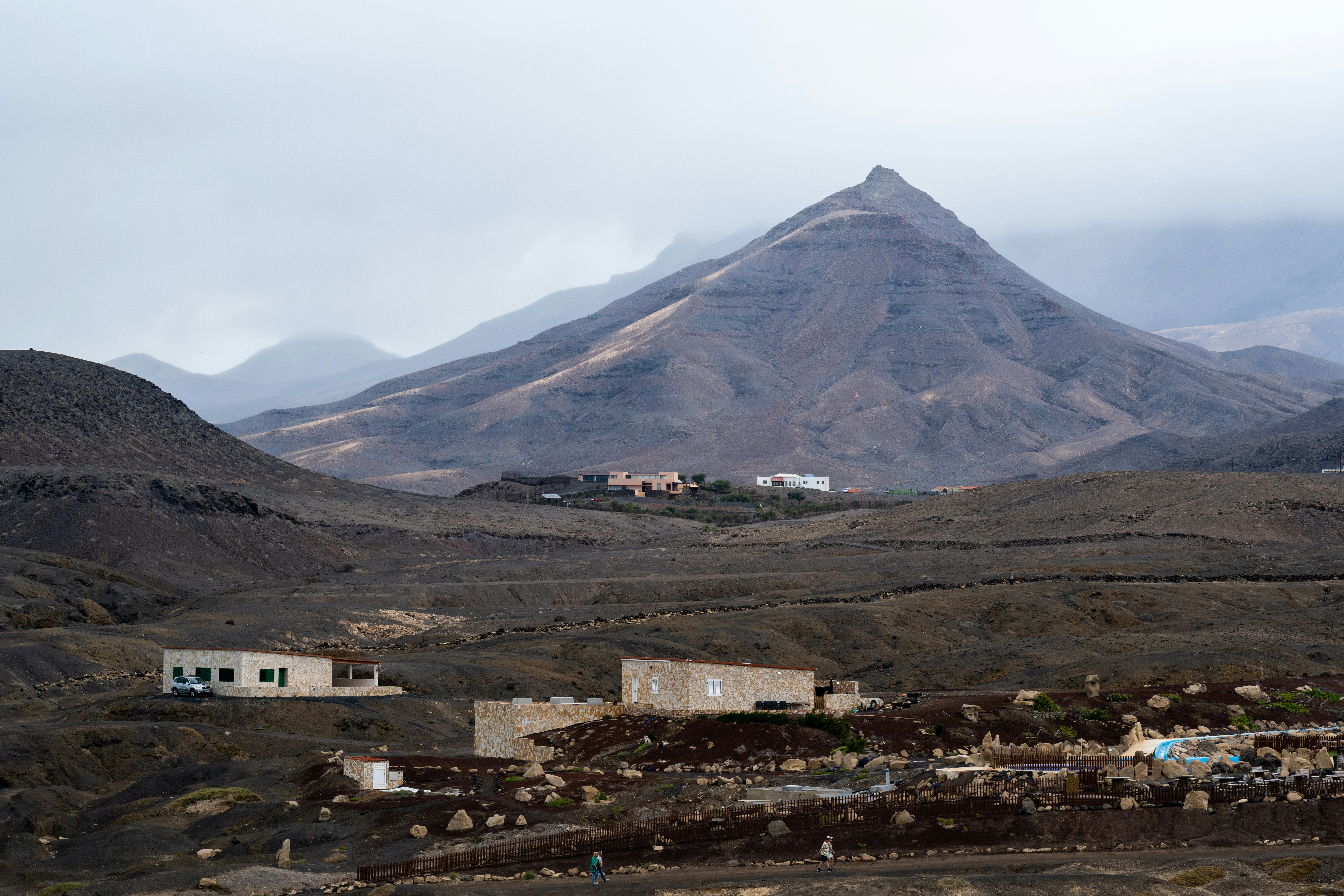 Karge Landschaft mit fernen Bergen und verstreuten Gebäuden