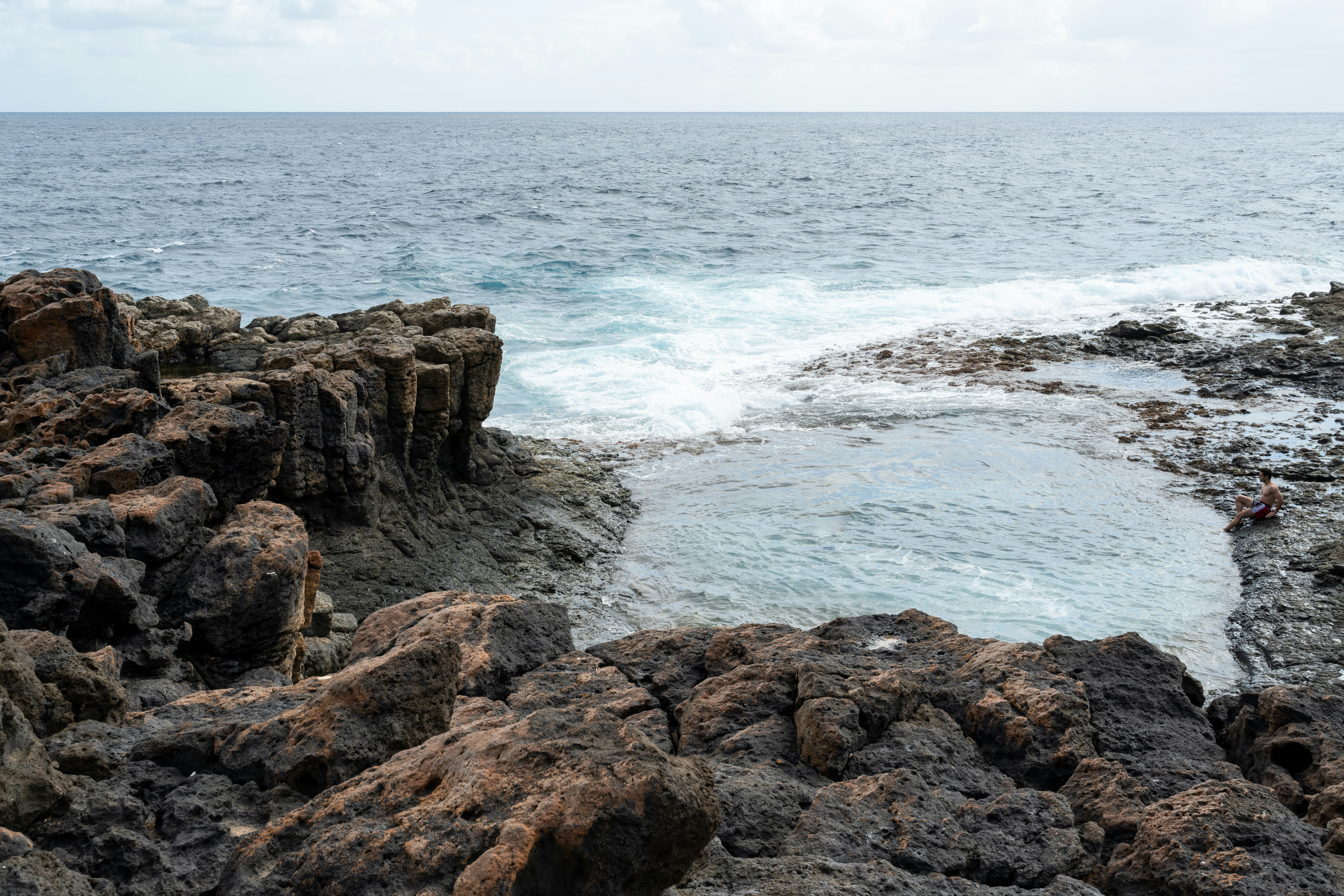 Felsige Küste mit ruhigen Gezeitenpools und Meereswellen