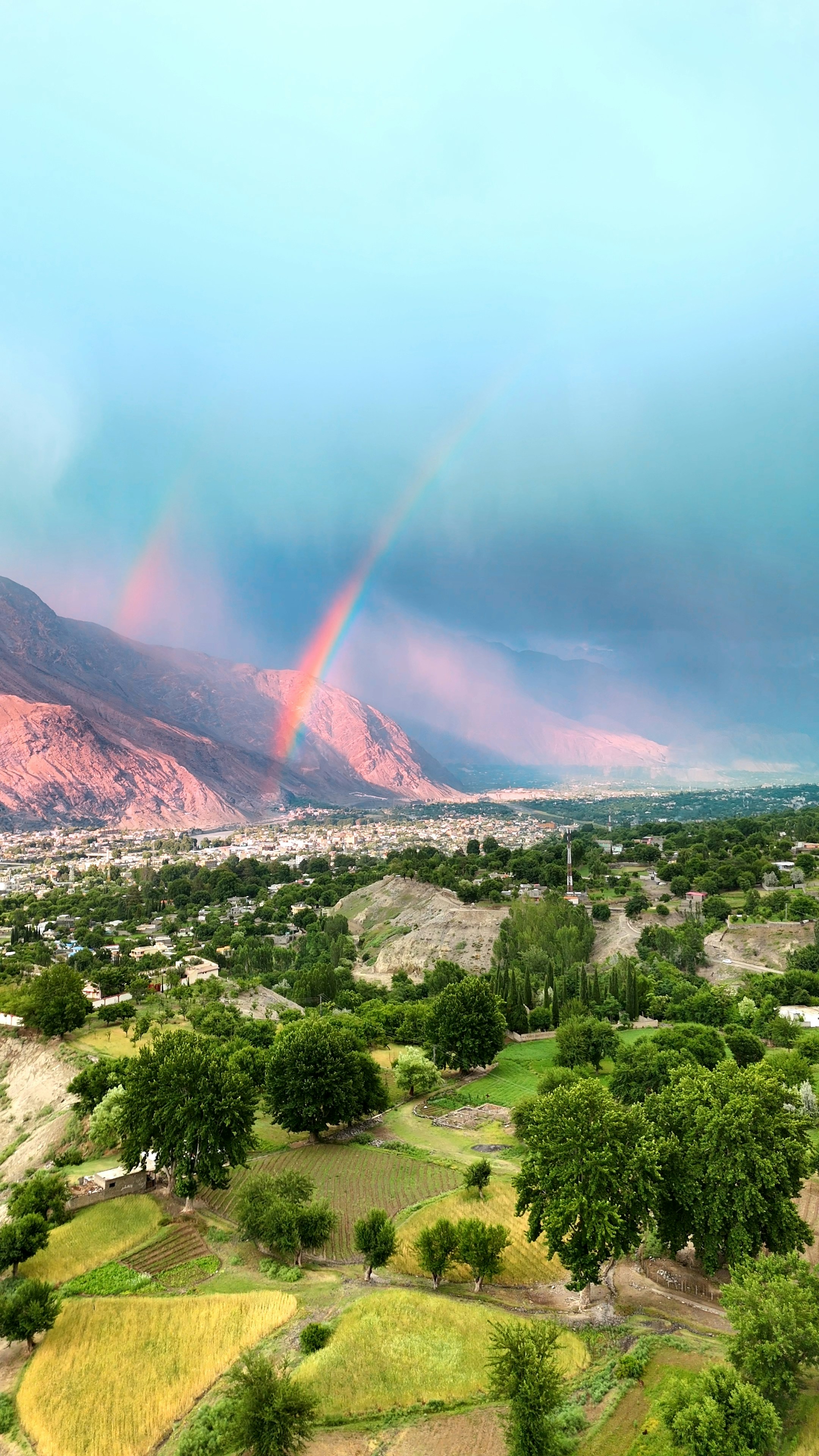 Rainbow over a village nestled in a valley